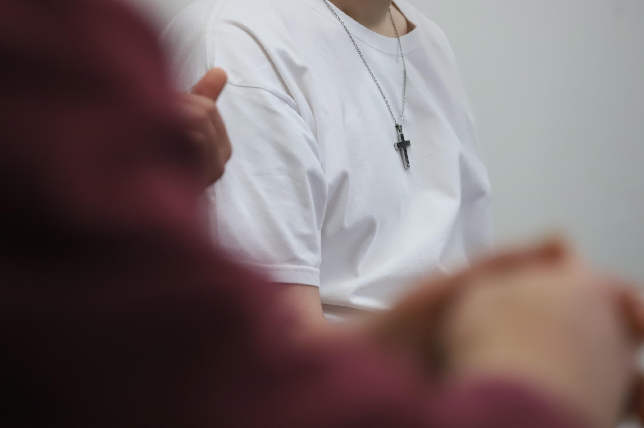 Ein Inhaftierter trägt ein Kreuz an einer Kette. Selbst religiöse Symbole müssen bei Haftantritt in der Kleiderkammer abgegeben werden. Wer dennoch ein Kreuz oder einen Rosenkranz haben möchte, kann sich an Diakon Reichert wenden.
