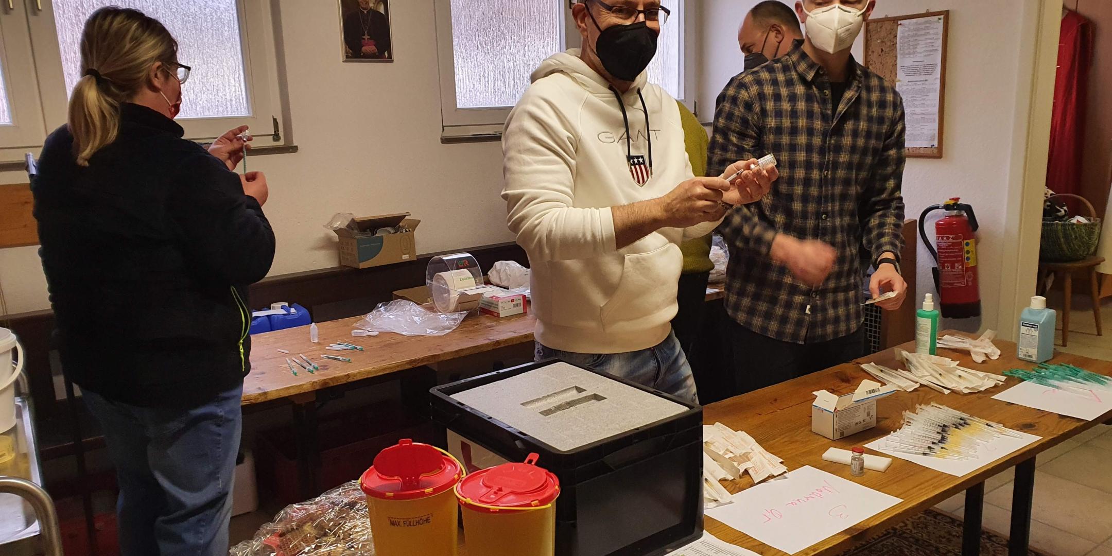 Helferinnen und Helfer bereiten in der Sakristei alles für die Impfung vor. Foto: Kirchengemeinde