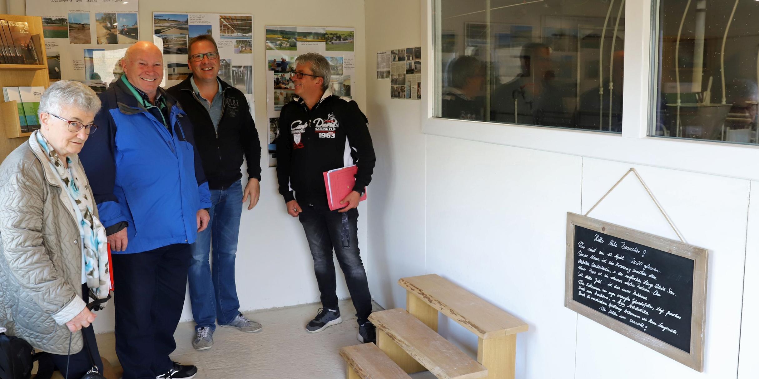 Hildegard Frey, Rudolf Leners, Markus Hansen und Raimund Fisch (v.l.n.r.) im offenen Besucherraum des Schweinemast- und Zuchtbetriebs. Durch die Glasscheibe kann man die Schweine beobachten. (Foto Inge Hülpes/Bistum Trier)