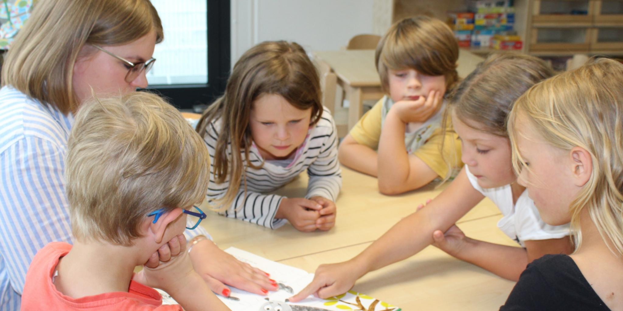 Die Vorschulkinder der katholischen Kita St. Pius besprechen gemeinsam ein Buch. Foto: Katholische KiTa gGmbH Koblenz/Cara Küpper