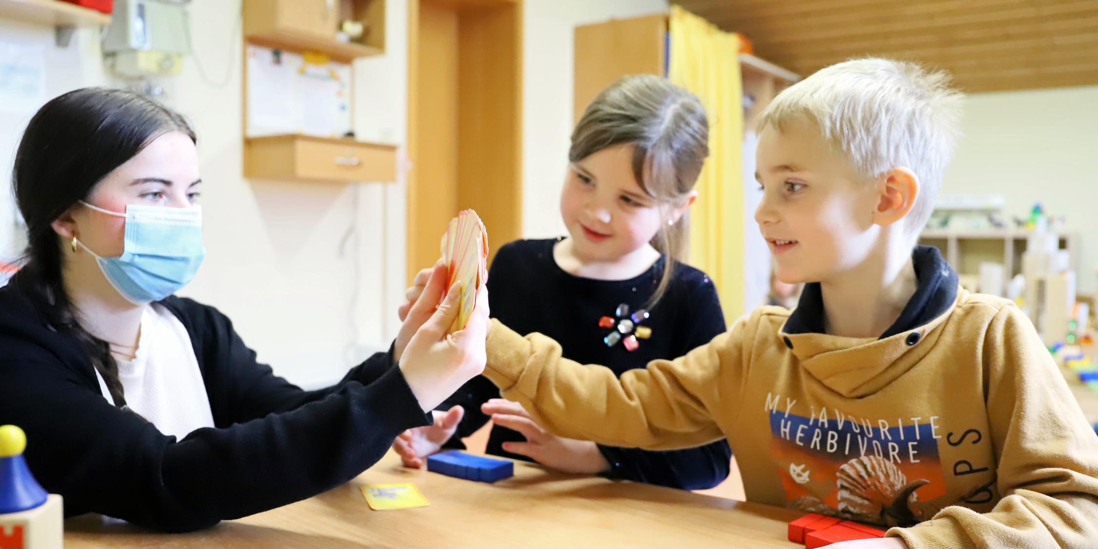 Mats und Ida spielen mit Erzierhin Jana Thömmes. in jedem Raum wird auf den Tischen ein Spiel angeboten, das die Kinder nutzen können - ebenso ist es mit Büchern, die immer zur Themenwelt des Raums passen.