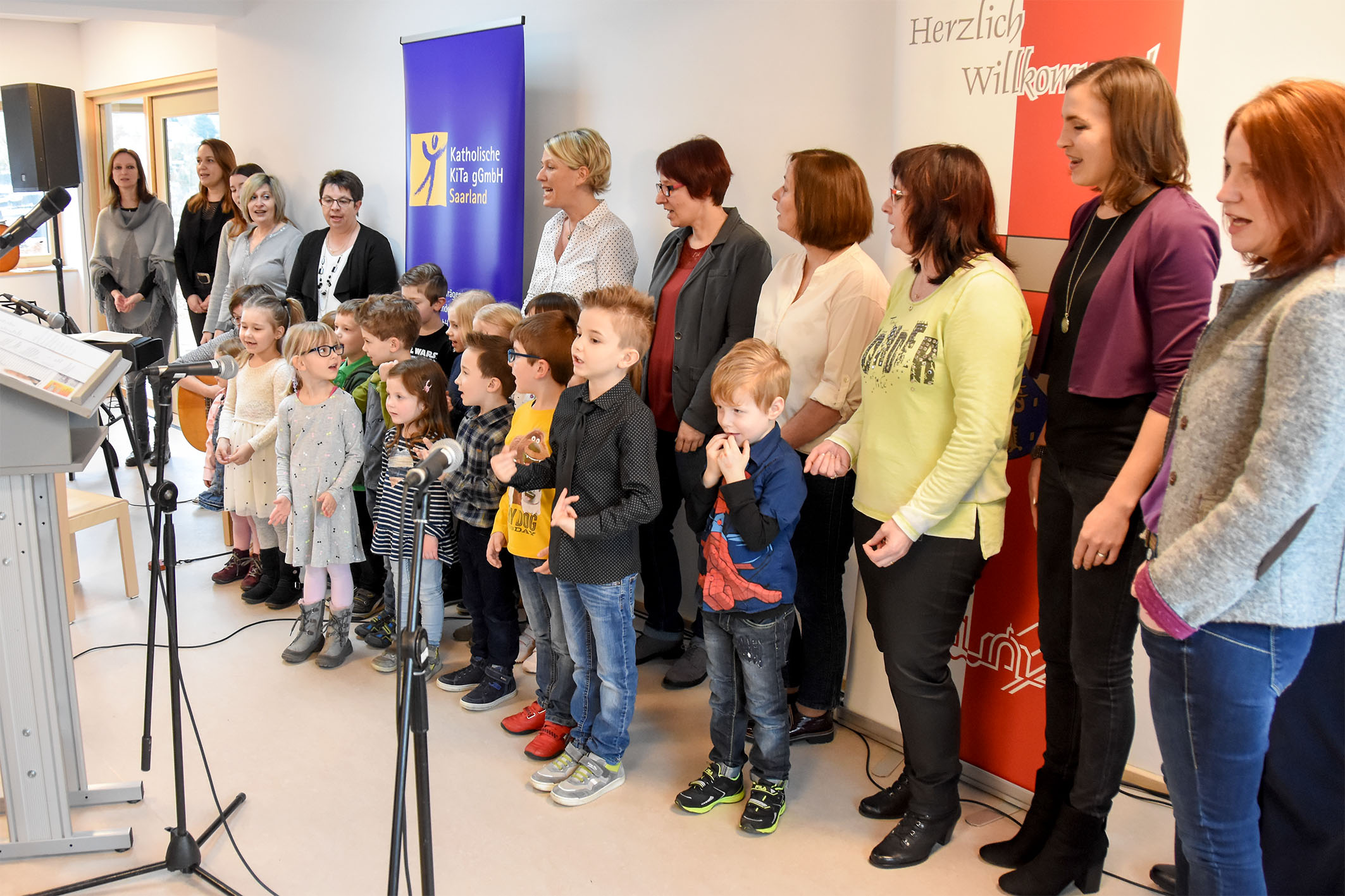 Erzieherinnen und Kita-Kinder singen gemeinsam ein Lied.
