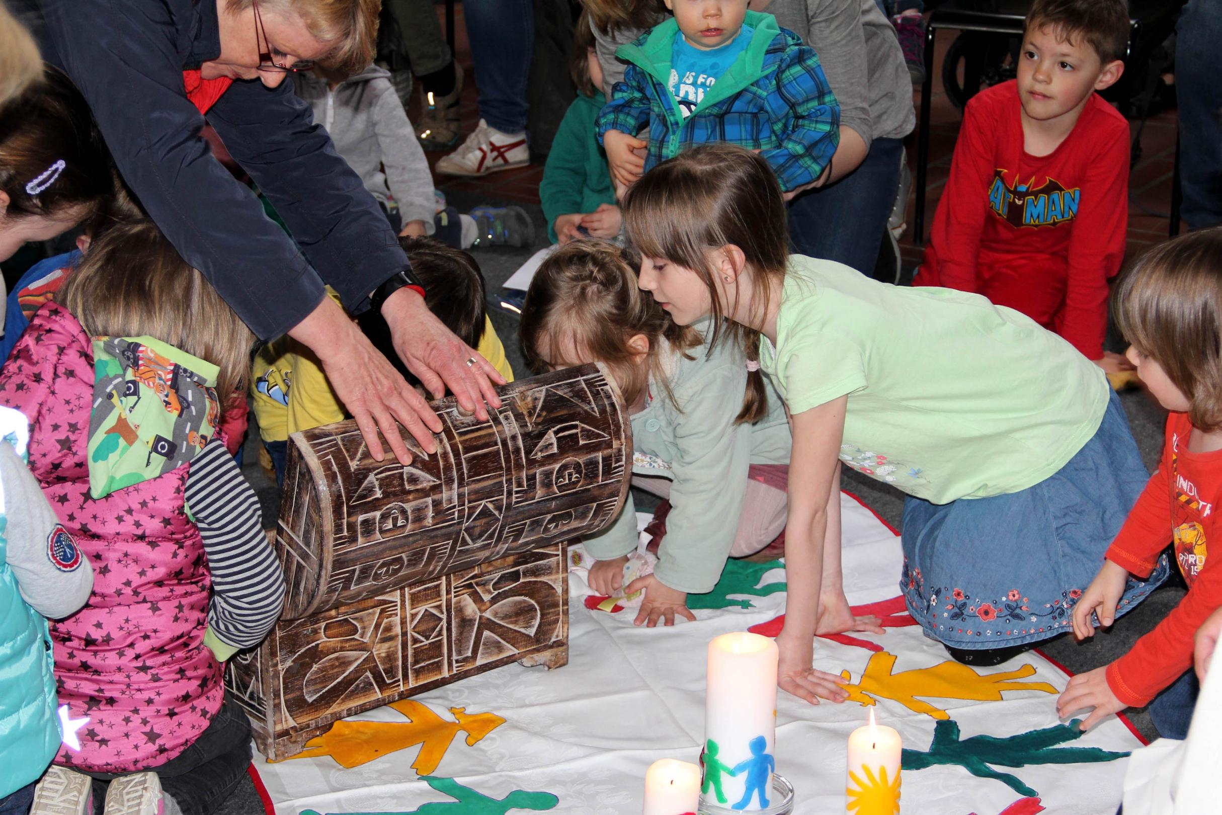 Gespannt schauen die Kinder in die Truhe