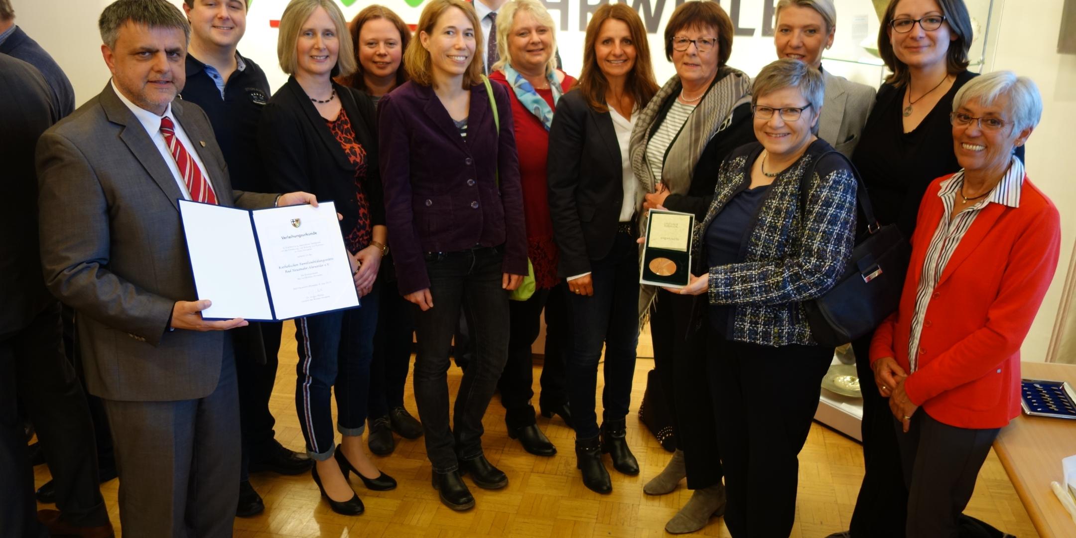 Pfarrer Peter Dörrenbächer (links), Leiterin Christine Kläser (Zweite v. rechts), ehemalige Leiterin der FBS Erika Heinen (hält die Plakette) und Referentin Familienbildungsstätten im Bistum Trier Monika Seidel (links neben Erika Heinen) sowie das Team bei der Verleihung