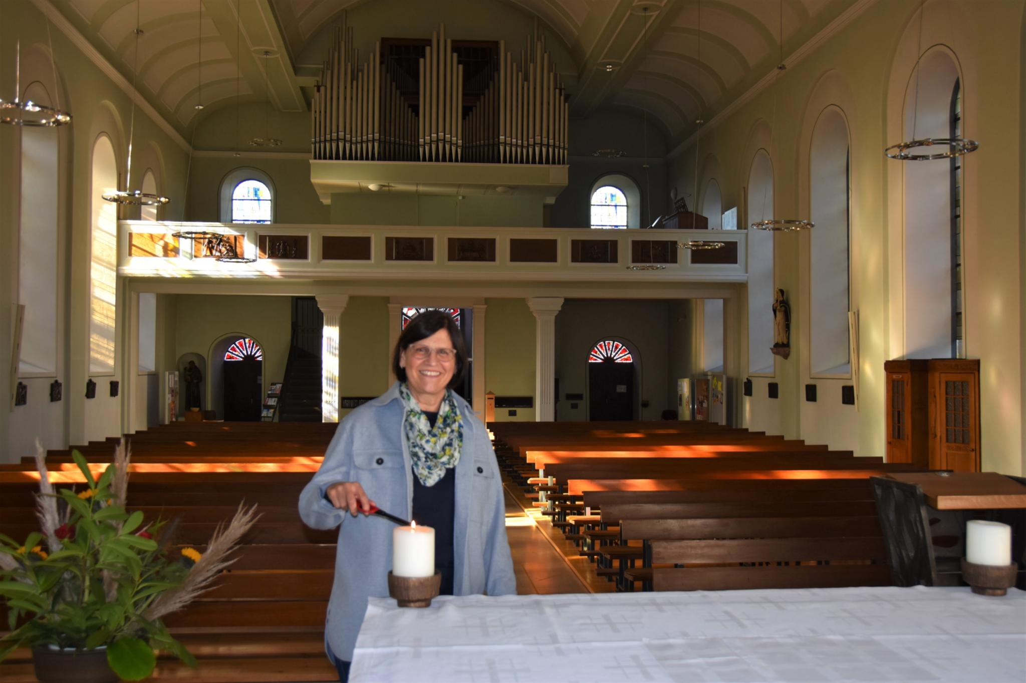 Vor den Gottesdiensten zündet Ellen Huwig die Kerzen am Altar an. Foto: Ute Kirch