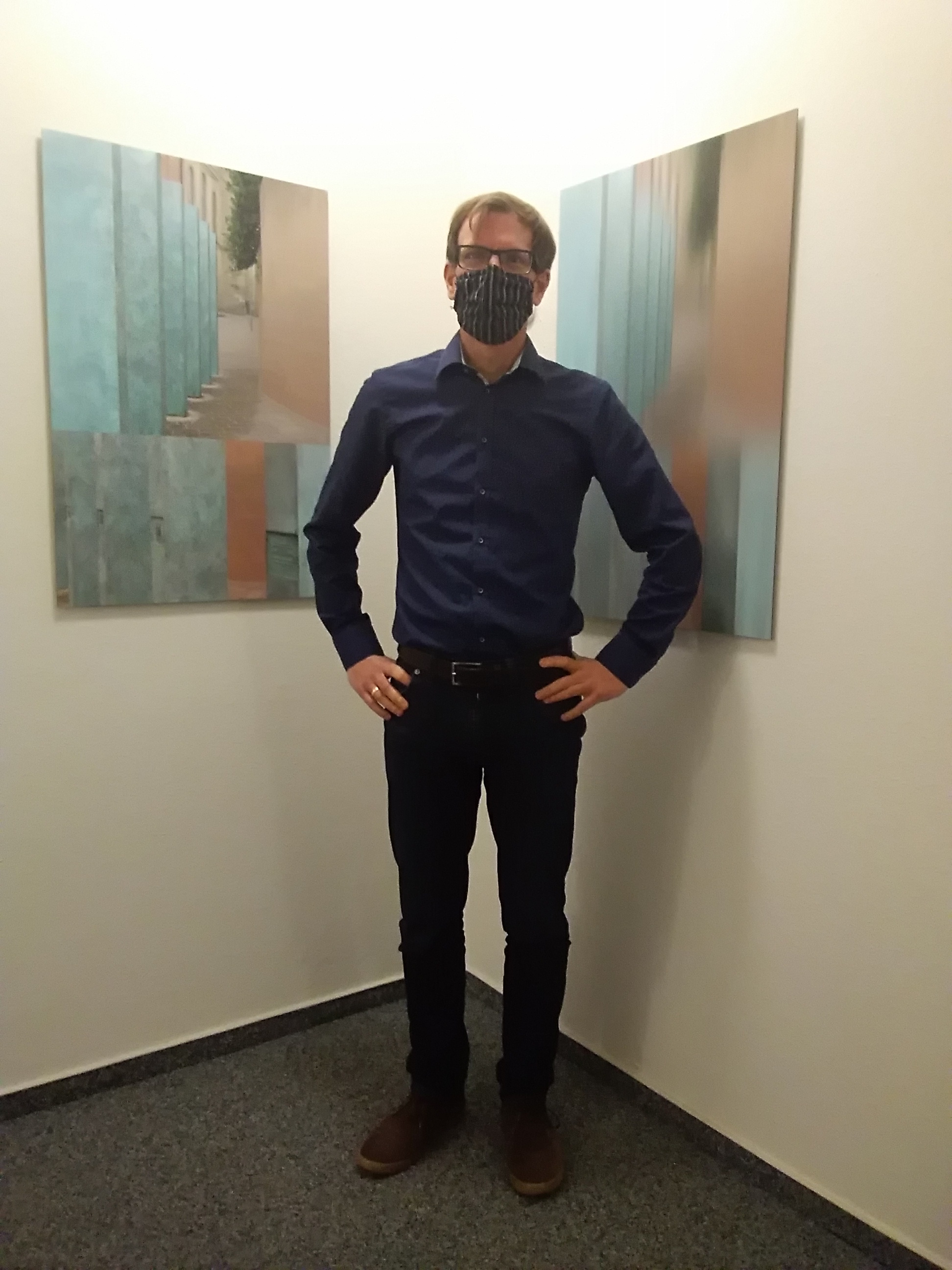 Dr. Tobias Gschwendner, Leiter der Lebensberatungsstelle in Trier, vor den Bildern der Trierer Künstlerin Sonja Weber, die seit letztem Jahr die Räume freundlich gestalten.