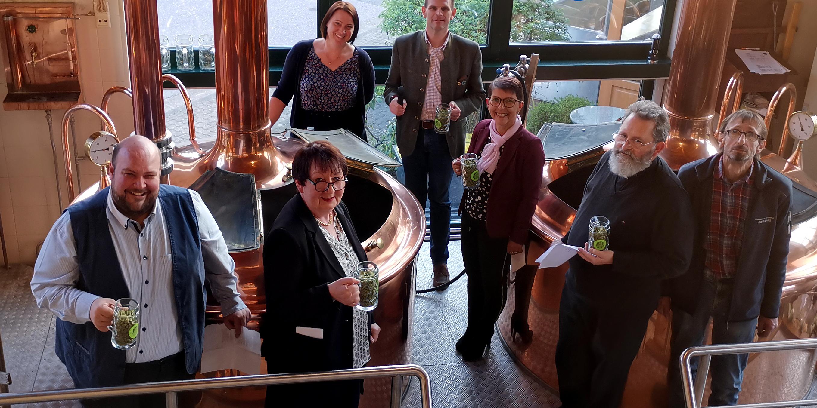 Als Braupaten fungierten (v.l.n.r.) Dennis Ernst (2. Vorsitzender des Lutwinuswerks), Ursula Graf-Rummel (1. Vorsitzende des Lutwinuswerks), der Mettlacher Bürgermeister Daniel Kiefer, Sonja Franz (Vorsitzende des Pfarreienrates direkt der Pfarreiengemeinschaft Mettlach) und Pfarrer Hans-Thomas Schmitt. Außerdem im Bild: Die Geschäftsführerin der Mettlacher Abtei-Brauerei, Anke Schorn (hintere Reihe), und Braumeister Altfred Maurer (rechts außen). Foto: Christina Libeaux