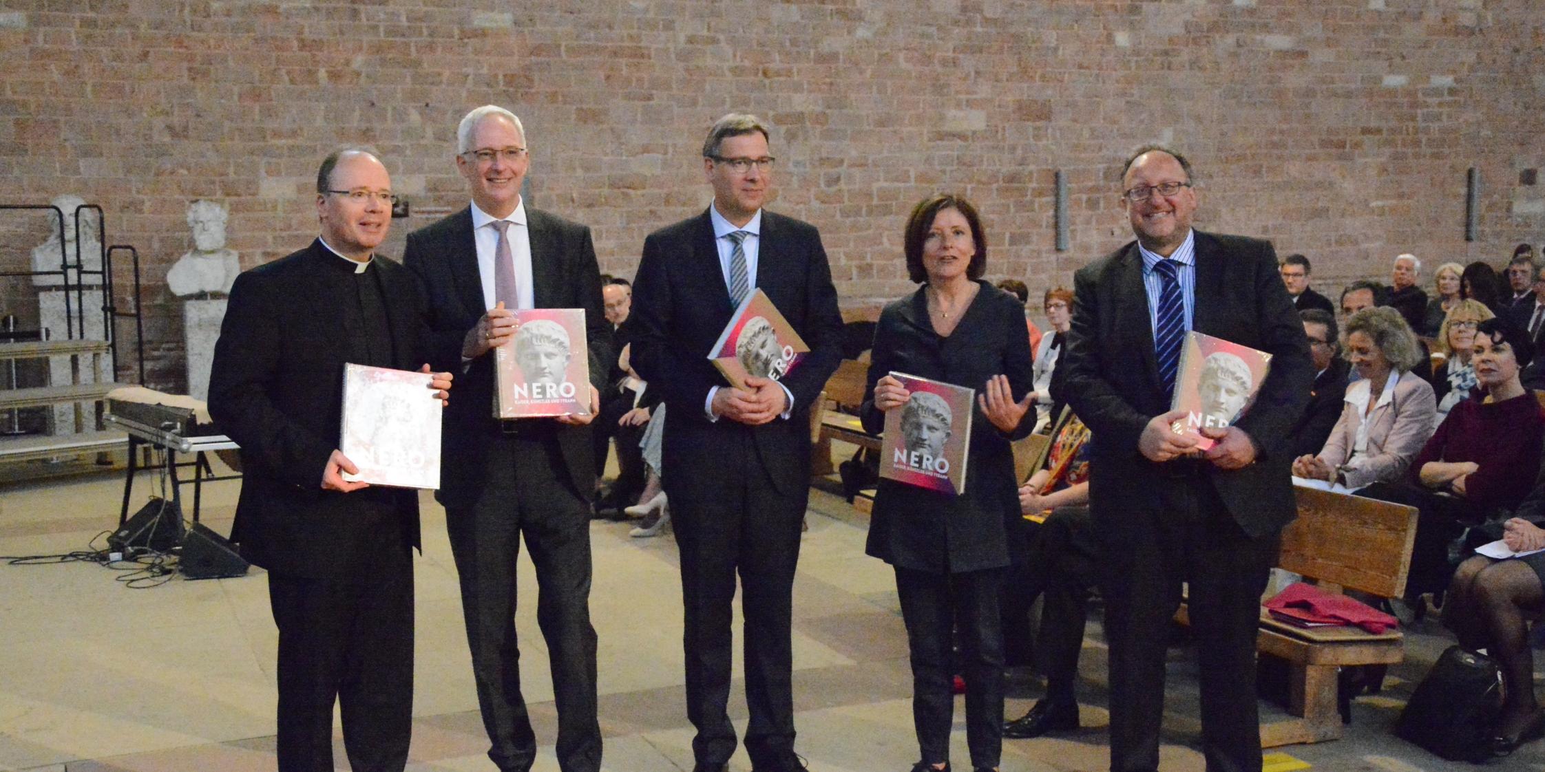 Bischof Dr. Stephan Ackermann (von links), Oberbürgermeister Wolfram Leibe, Superintendent Dr. Dr. Jörg Weber, Ministerpräsidentin Malu Dreyer und Prof. Dr. Christian Witschel (Universität Heidelberg) erhalten als erste eine Ausgabe des Begleitbands zur Ausstellung überreicht.