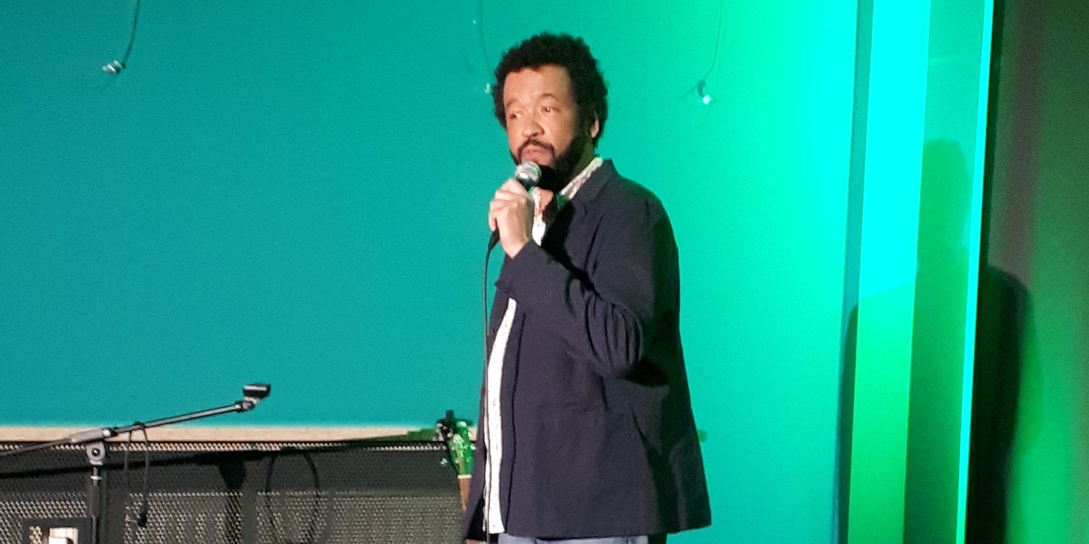StandUp Kabarettist Marius Jung spricht zu den Teilnehmenden im Café