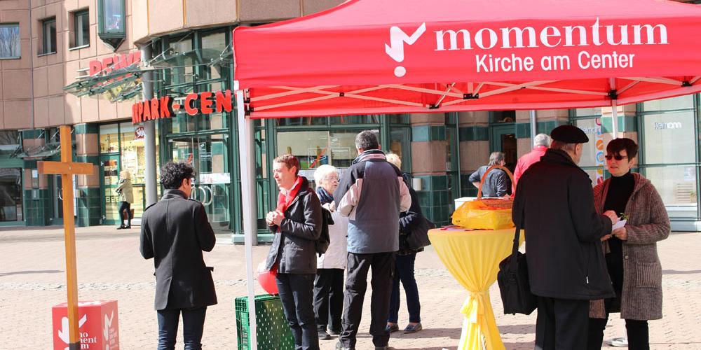 Mitarbeiterinnen von 'Momentum' verteilen gesegnete Palmsträuße in der Neunkircher Innenstadt