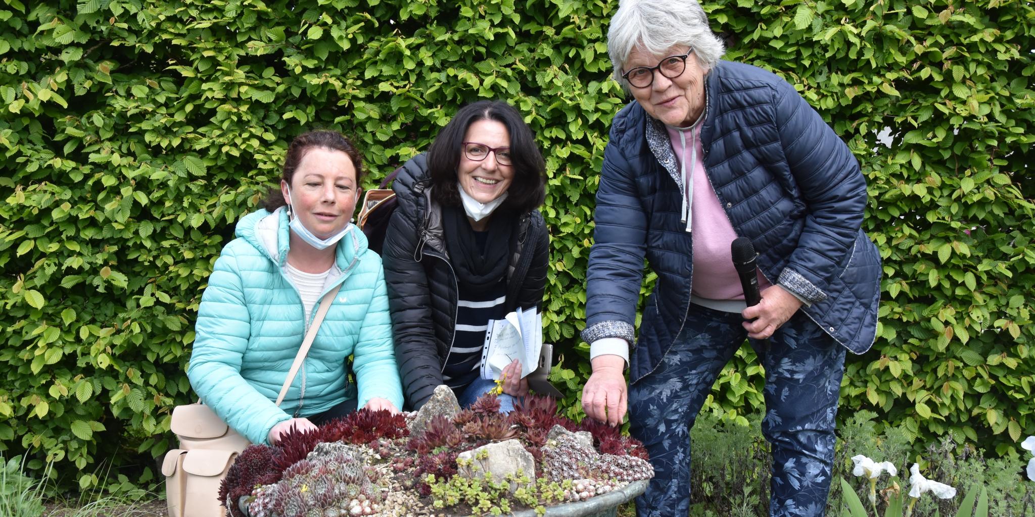 Nicole Hemmerling, Hiltrud Scherer (Begleitperson) und Ulrike Heffinger, Leiterin des Projektbüros Gärten ohne Grenzen, vor einem Pflanzenkübel mit Sedum. Foto: Ute Kirch/Bischöfliche Pressestelle