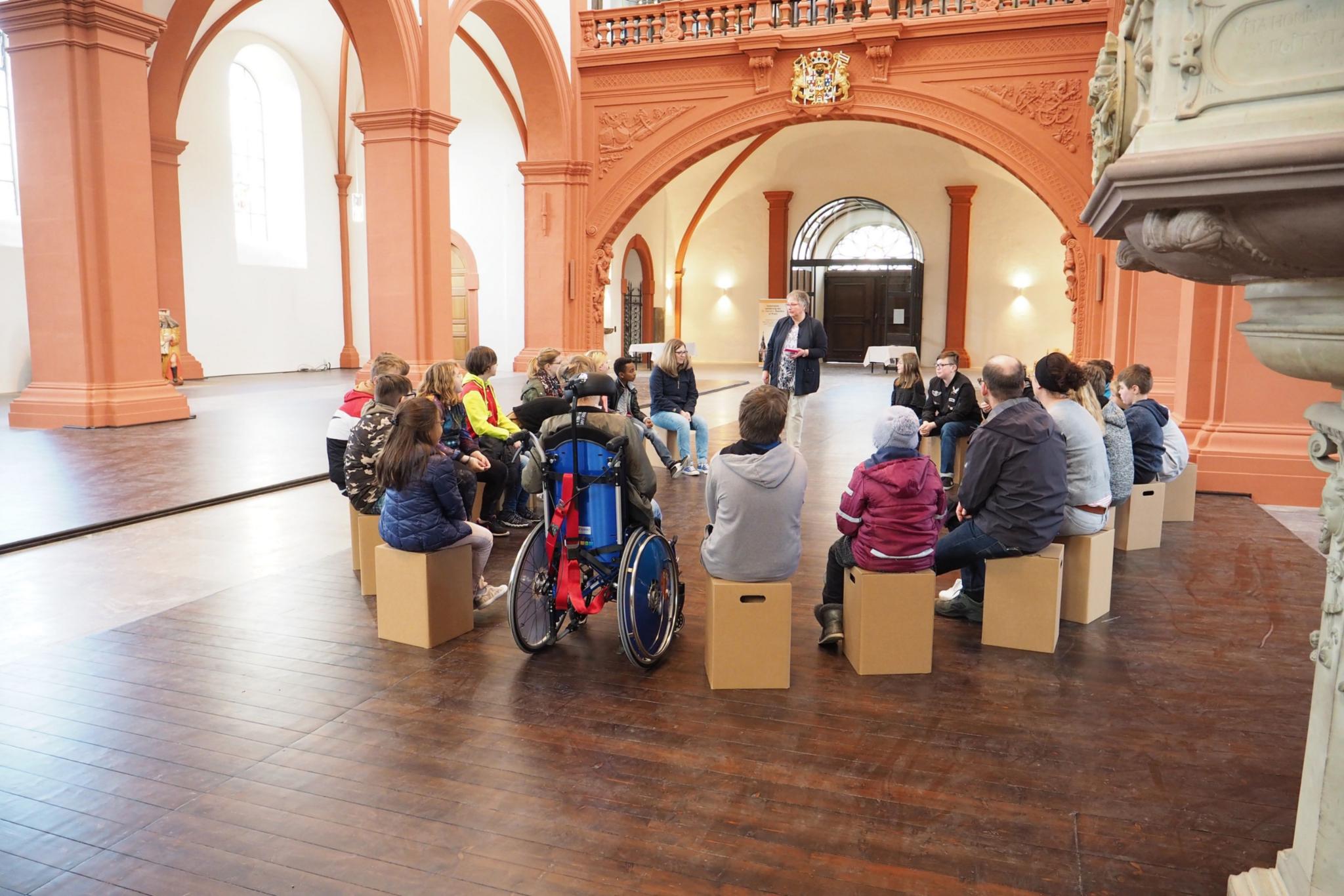Schüler der Astrid-Lindgren-Förderschule gemeinsam mit der Gemeindereferentin (stehend) im weiten Kirchenraum der Basilika.