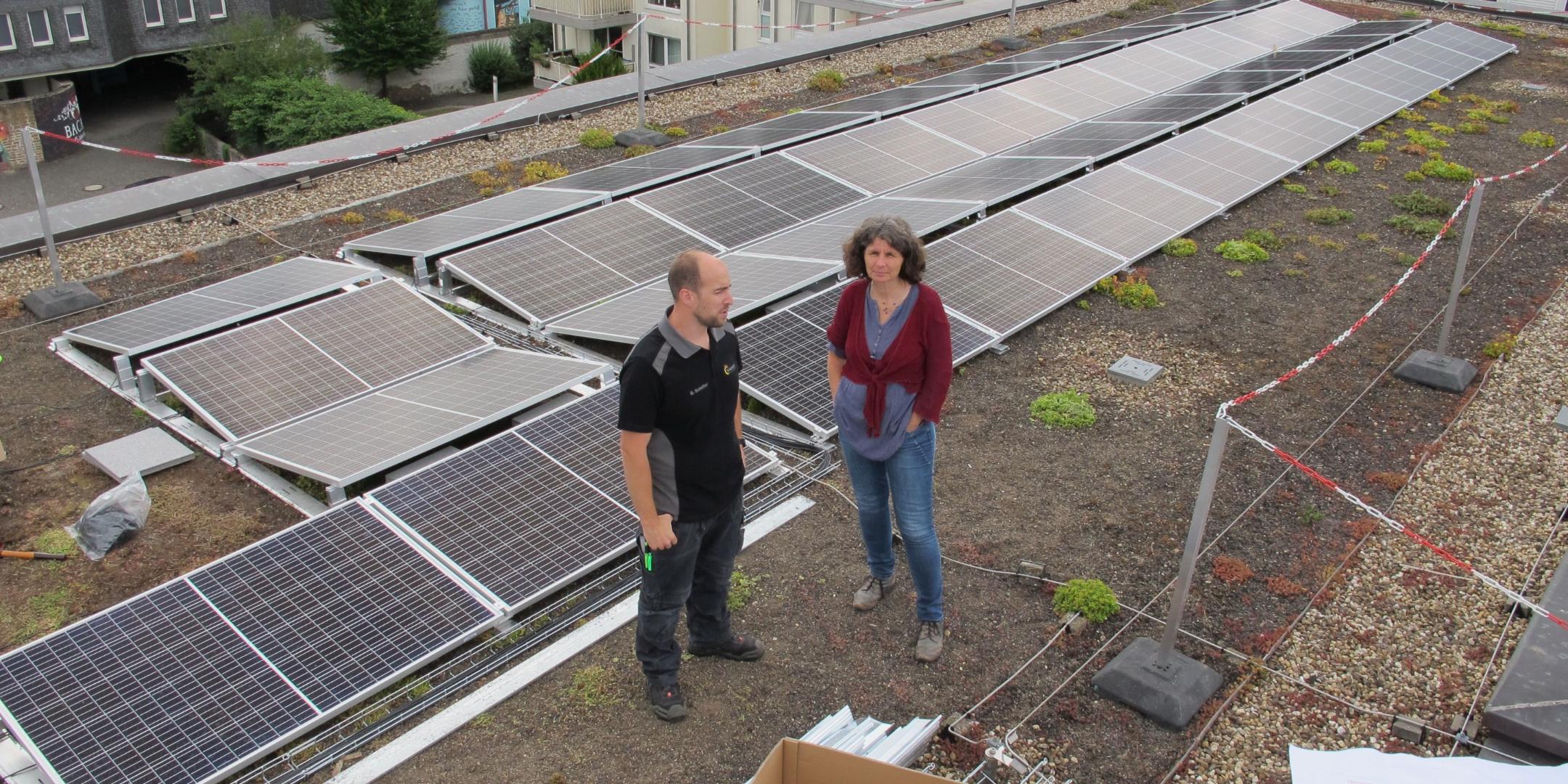 Bernd Schöller von der Firma SchoEnergie aus Föhren mit der Klimaschutzmanagerin Charlotte Kleinwächter auf dem Dach des Angela-Merici-Gymnasiums in Trier.