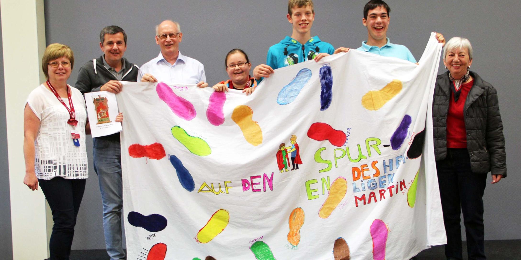 Dirk Kempf (2vl), Alwina Seidel (4vl), Peter Kirsten (5vl) und Dennis (6vl) mit Begleitern und einer selbstgestalteten Flagge aller Teilnehmenden „auf den Spuren des Heiligen Martins“