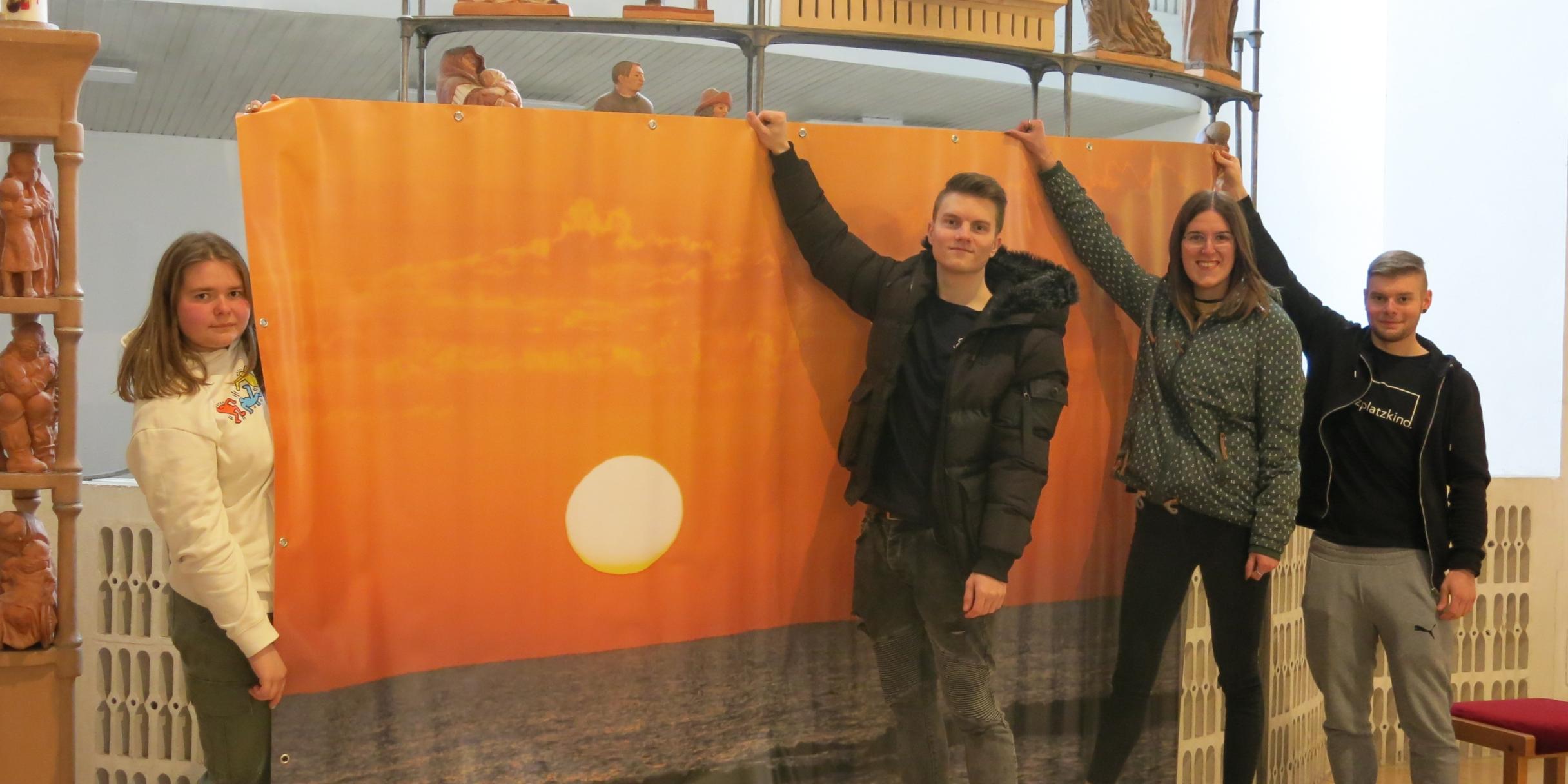 Bringen Plakatmotiv zentral im Altarbereich an, damit es von überall einsehbar ist: Chantal Schwinn, Tim Lessel, Franziska Dengler und Adrian Schwinn. Foto: Klaus Friedrich