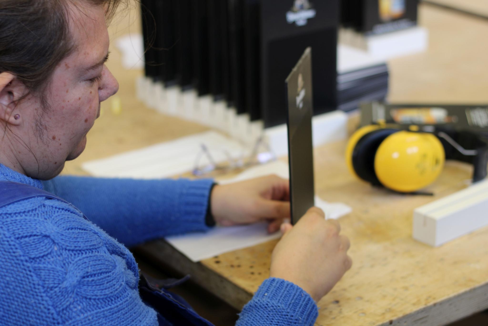 Sabrina Pauly-Fechner klebt Tisch-Aufsteller zusammen.