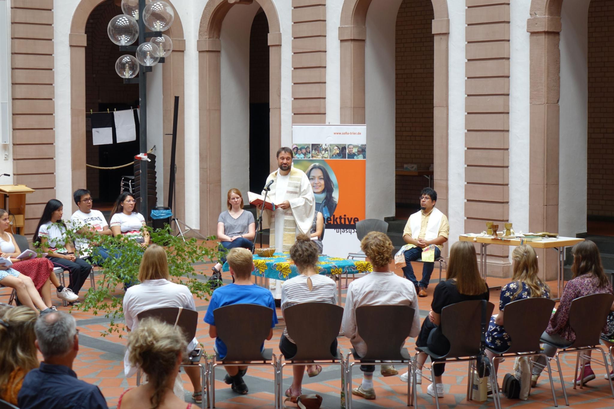 13 junge Freiwillige und deren Familien kamen in der Aula des AMG Trier zusammen, um gemeinsam mit Kaplan Michael Meyer Eucharistie zu feiern. (Foto: Bistum/Foltin)