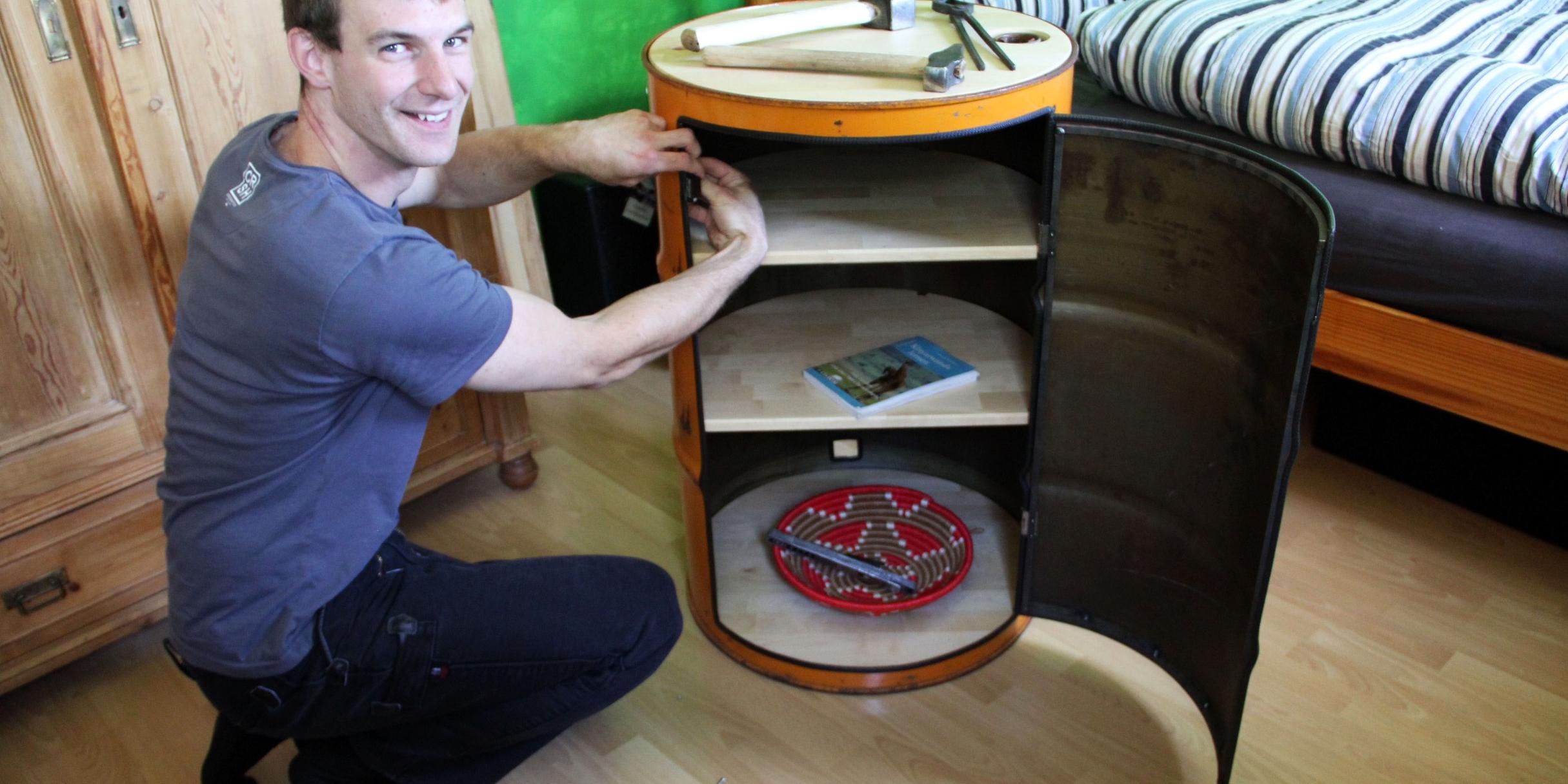 Dominik Unterrainer bastelt an einer Öl-Tonne, die er zu einem Regal umbaut