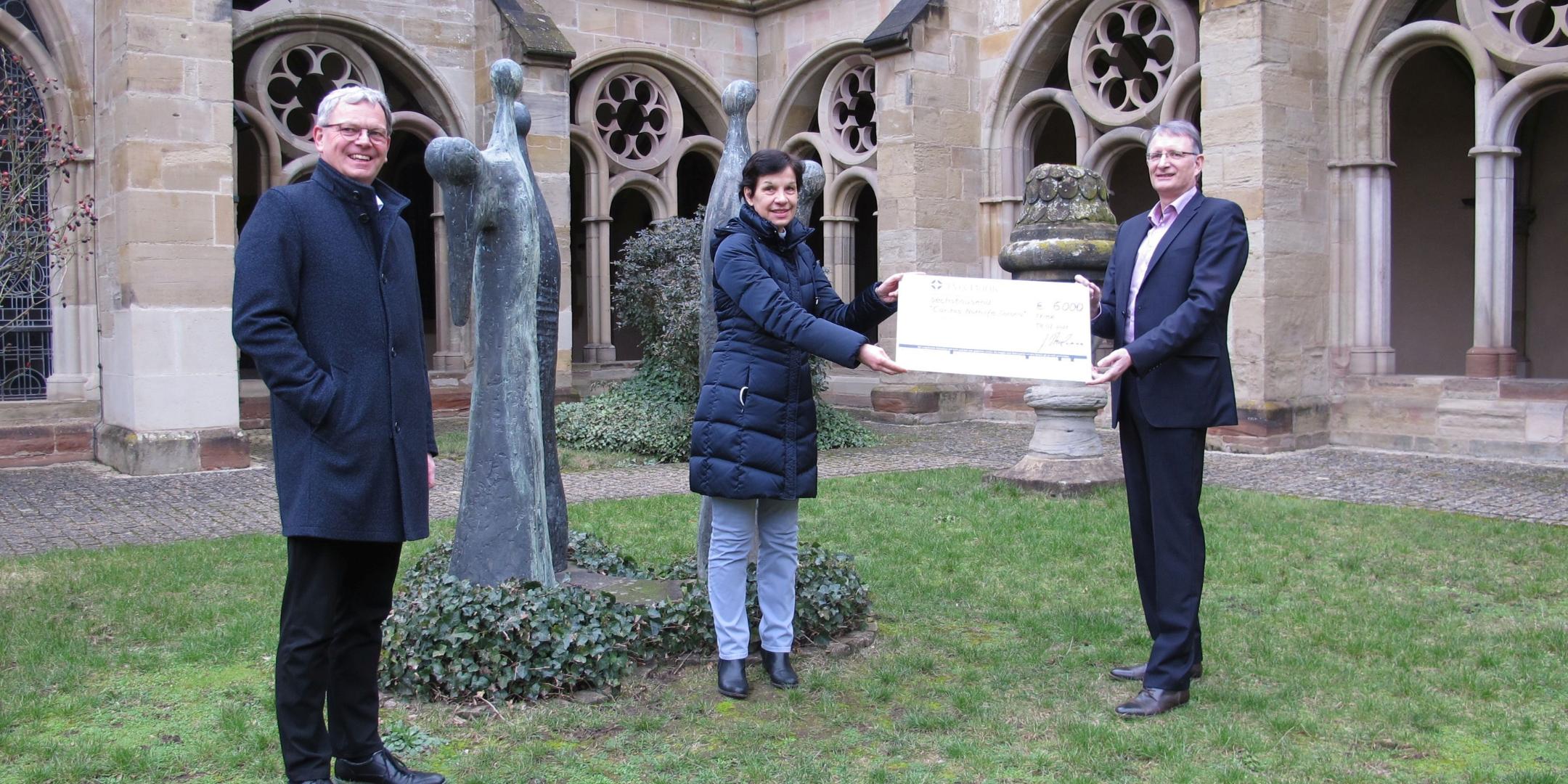 vlnr. bei der Scheckübergabe: Generalvikar Dr. Ulrich Graf von Plettenberg, Caritas-Direktorin Dr. Birgit Kugel und Johannes Thielmann, Geschäftsführer des Paulinus-Verlags (Foto: Stefan Schneider)