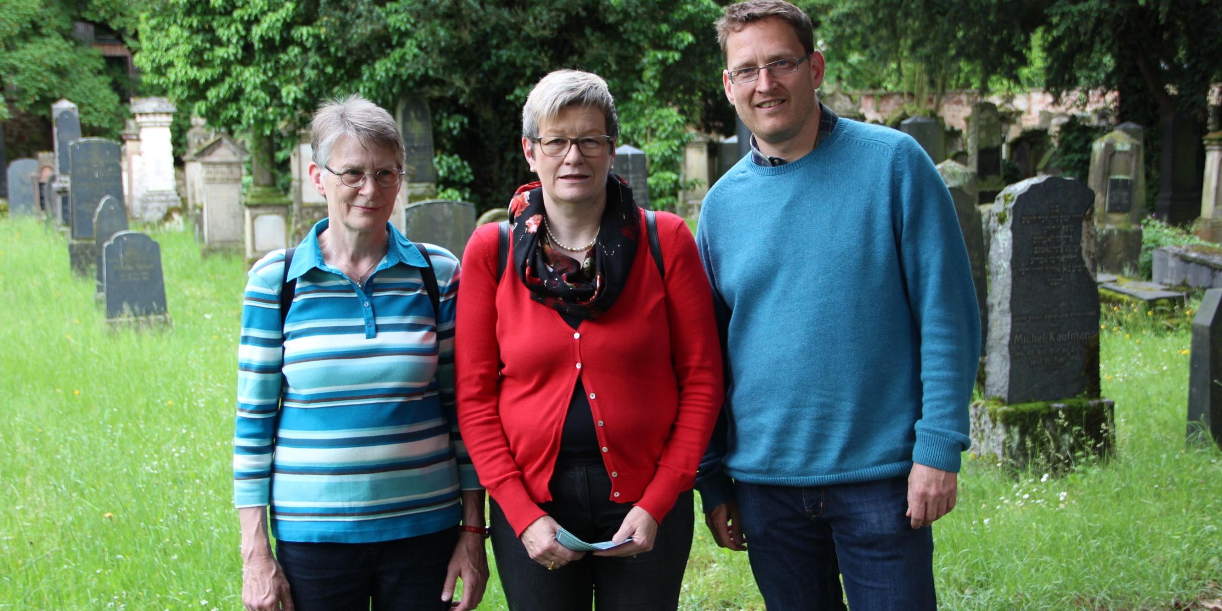 Waltraud Stahl (Hospiz Verein Trier), Beate Barg und Roland Hinzmann (Dekanat Schweich-Welschbillig; vlnr) bei einer Führung am jüdischen Friedhof Trier - eine der Veranstaltungen des Projekts.