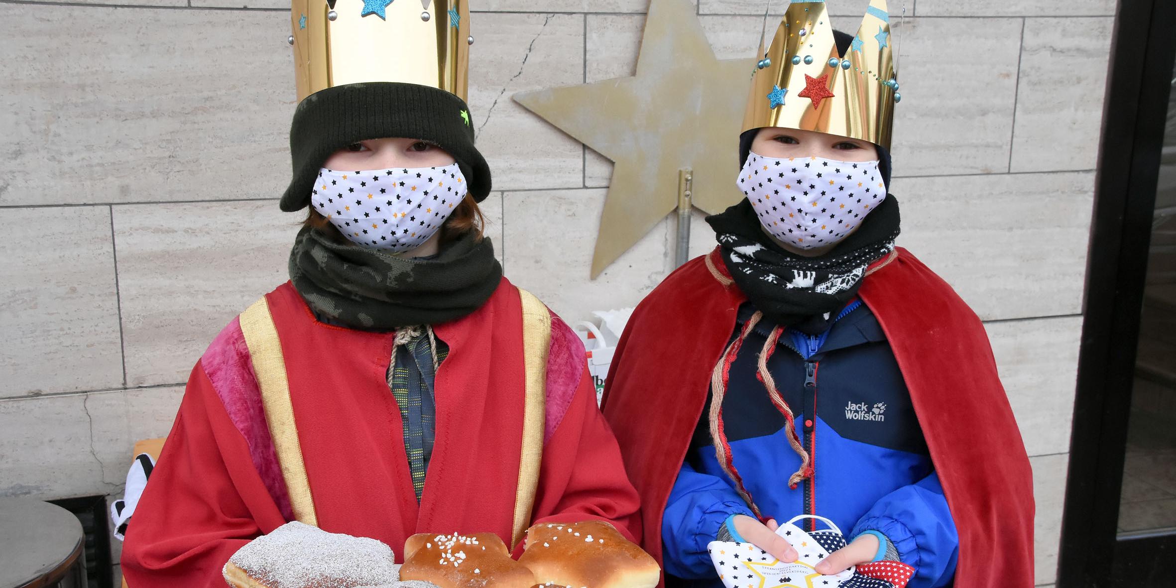 An der Segenshaltestelle an der Bäckerei Krämer: Henri Jung (l) mit Segenssternen aus der Bäckerei und Linus Meyer (r) mit den in jeder Segenstüte enthaltenen Atem-Masken, die eigens für die Aktion hergestellt wurden. Foto: Hans Georg Schneider