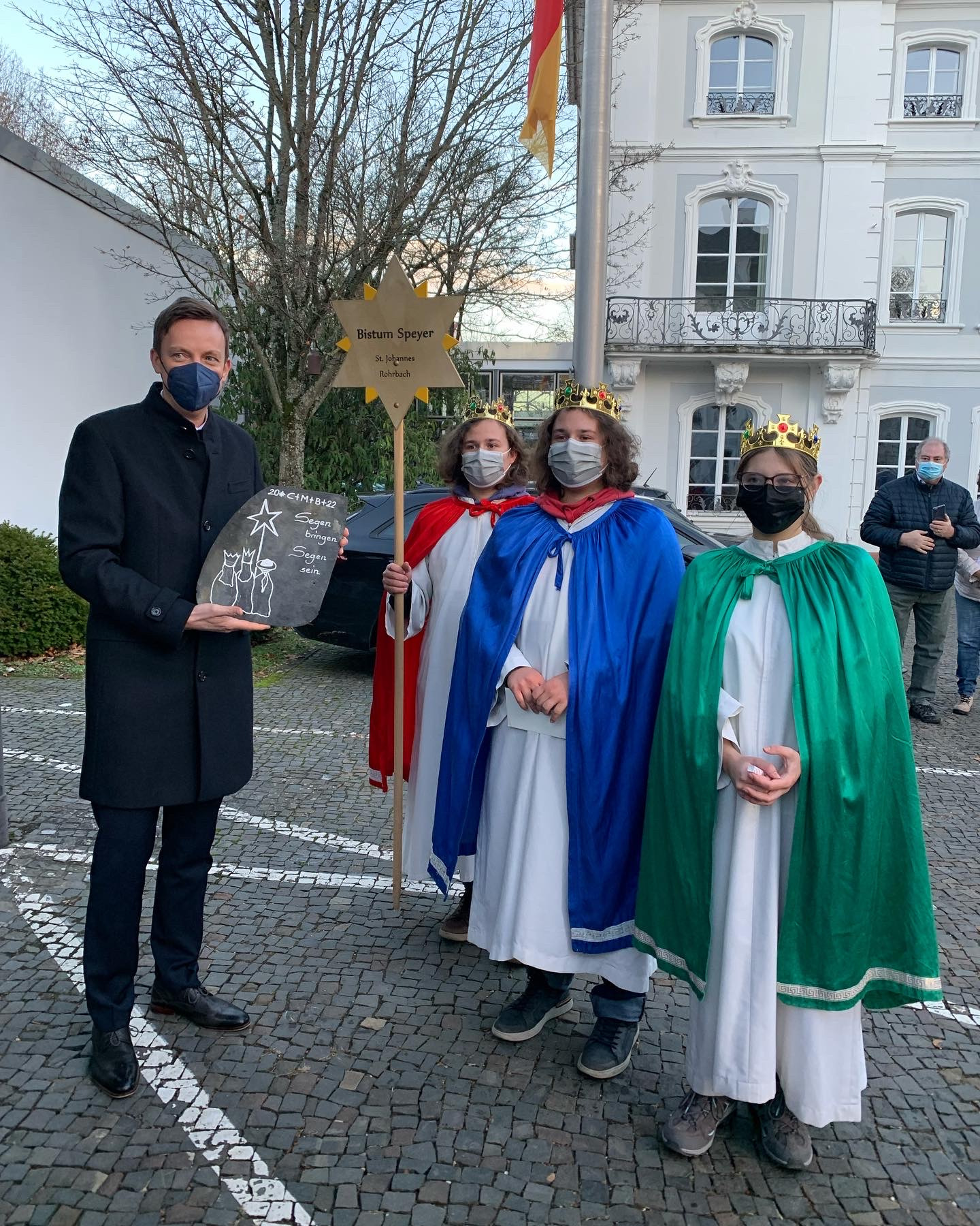 Sternsinger Damian, Jan und Mona aus St. Ingbert-Rohrbach (Bistum Speyer) überreichen Hans eine Schieferplatte des renovierten Kirchendaches. Foto: Ute Kirch