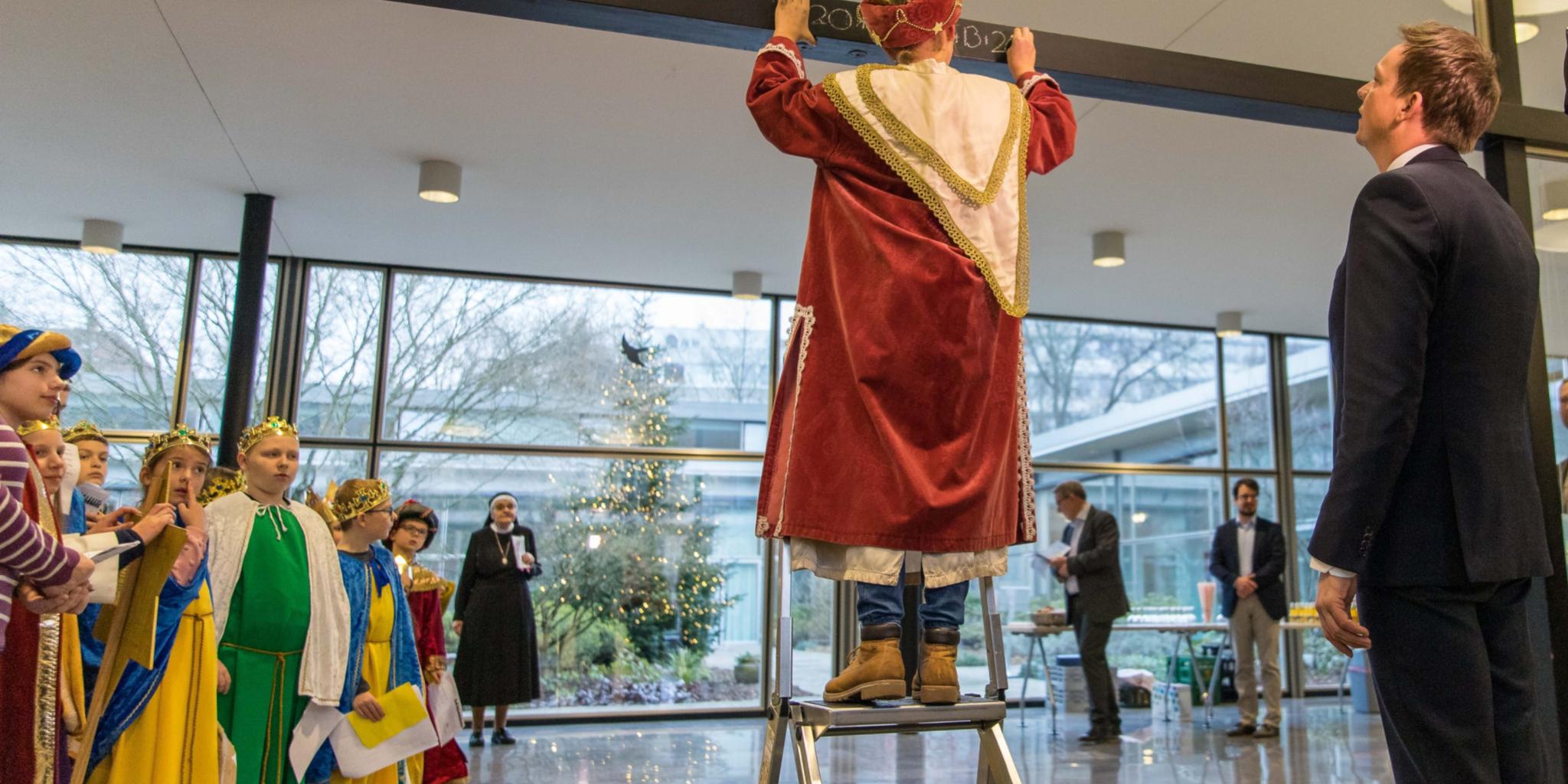 Ein Sternsinger beim Schreiben des Segens (Quelle: Staatskanzlei Saarland)