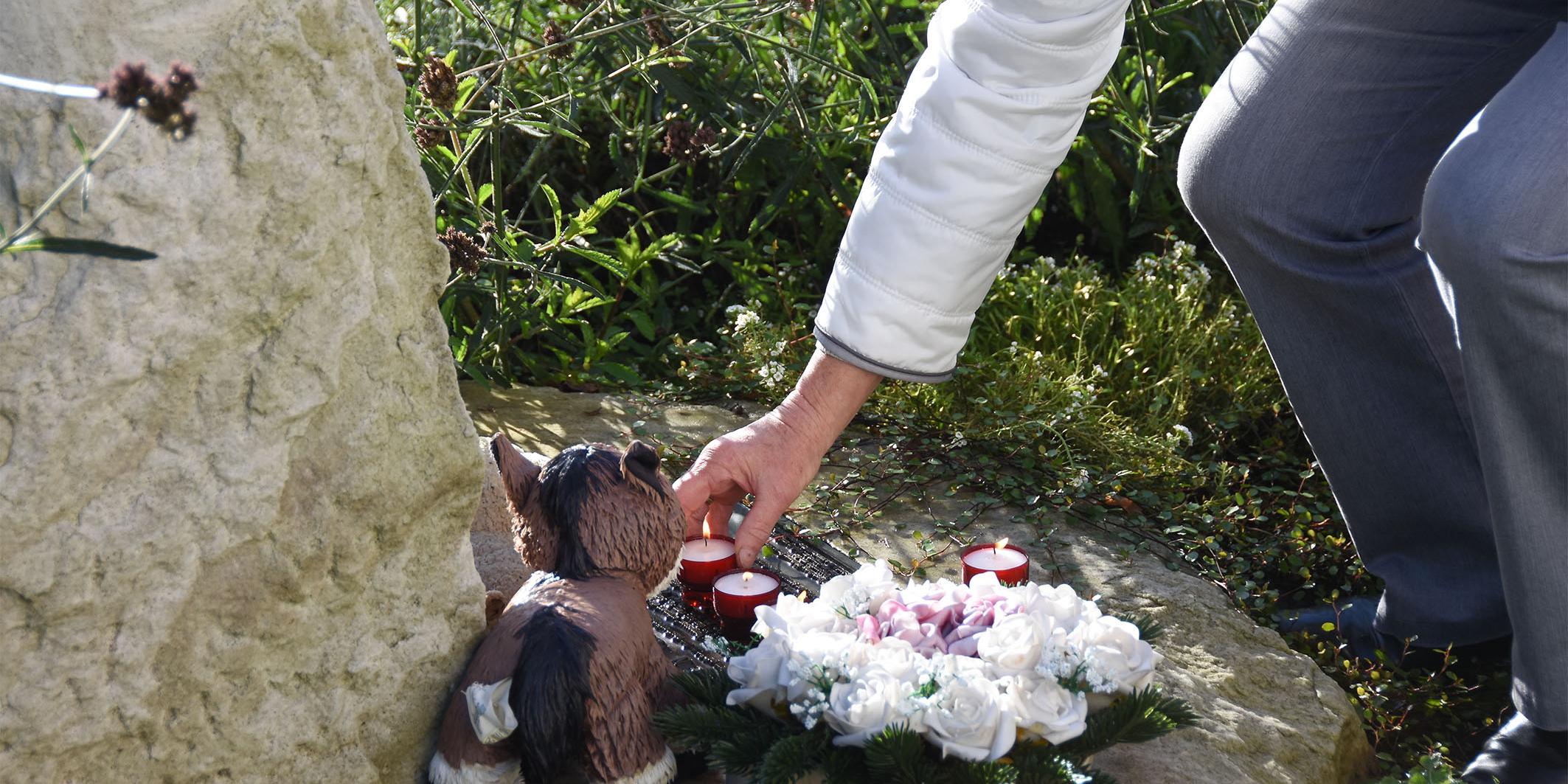 Auf dem Friedhof der Kirche St. Martin legten die Gemeindemitglieder Kerzen am Gedenkstein für die Opfer von Missbrauch nieder.
