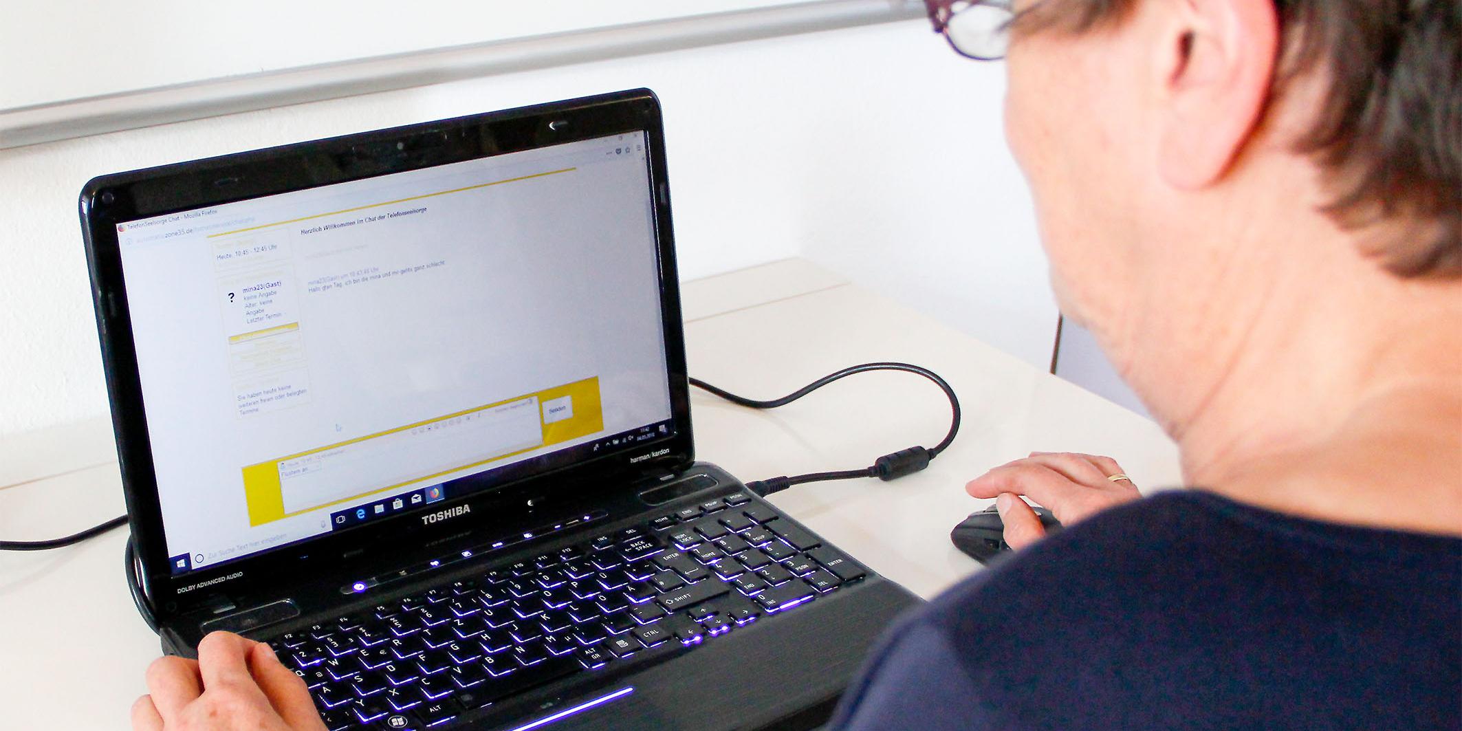 Digitalisierte Seelsorge: Eine der Ehrenamtlichen vor dem geöffneten Chatfenster der Telefonseelsorge.
