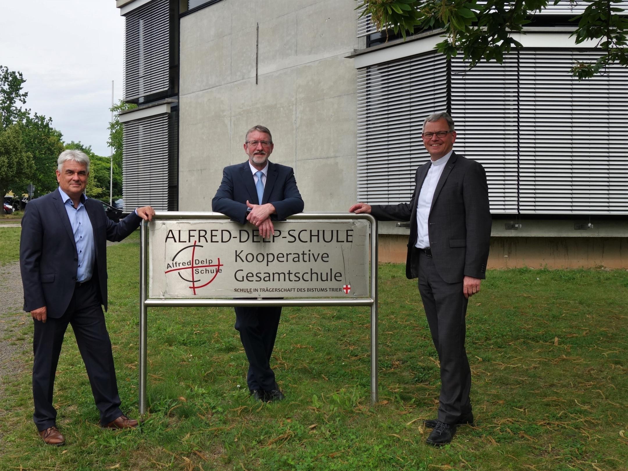 Albrecht Adam (Leiter der Abteilung Schule und Hochschule im Bischöflichen Generalvikariat Trier; links) und der Trierer Generalvikar und ehemaliger Schulpfarrer der ADS Dr. Ulrich Graf von Plettenberg (rechts) verabschieden den Gesamtschulleiter Günter Graus in den Ruhestand. Foto: Bischöfliche Pressestelle/Julia Fröder