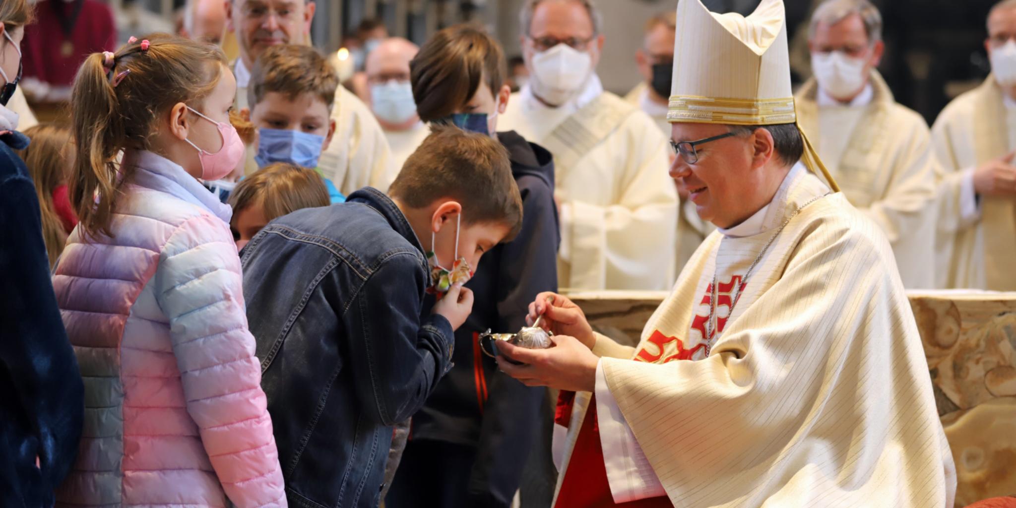 Die Kommunionkinder aus der Pfarreiengemeinschaft Ulmen riechen an dem gemischten Öl. (Fotos: Inge Hülpes/Bistum Trier)