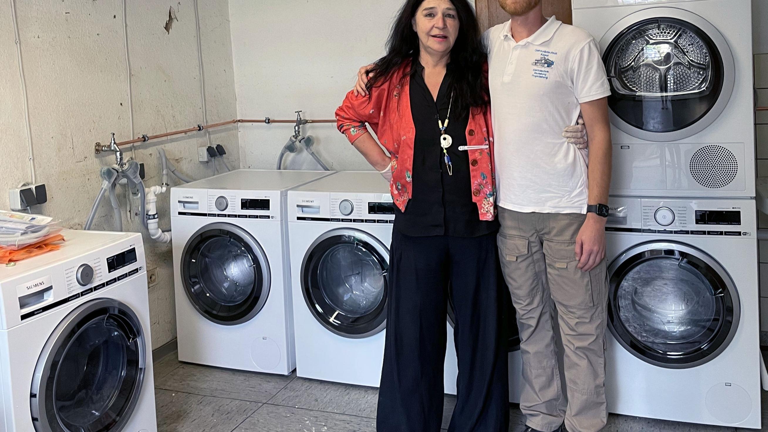 Die Leiterin des HoT, Petra Klein, mit einem Elektrikermeister aus dem brandenburgischen Senzech. Die Waschmaschinen und ihr Anschluss waren eine Spende. Für die Betroffenen aus dem Ahrtal wurde so im HoT ein Waschsalon eingerichtet, wo kostenlos gewaschen werden kann. (Foto: privat)