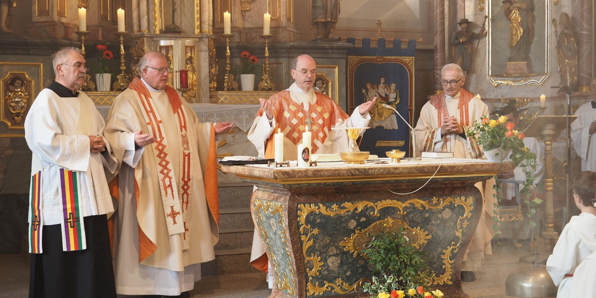 Diakon Karl Weyandt, Pfarrer Georg Josef Müller, Weihbischof Robert Brahm und der Ruhestandsgeistliche Pfarrer Friedrich Kreutz (von links) feiern das Hochamt am Altar der Pfarrkirche St. Johannes der Täufer. (Foto: Stefan Endres/Bistum Trier)