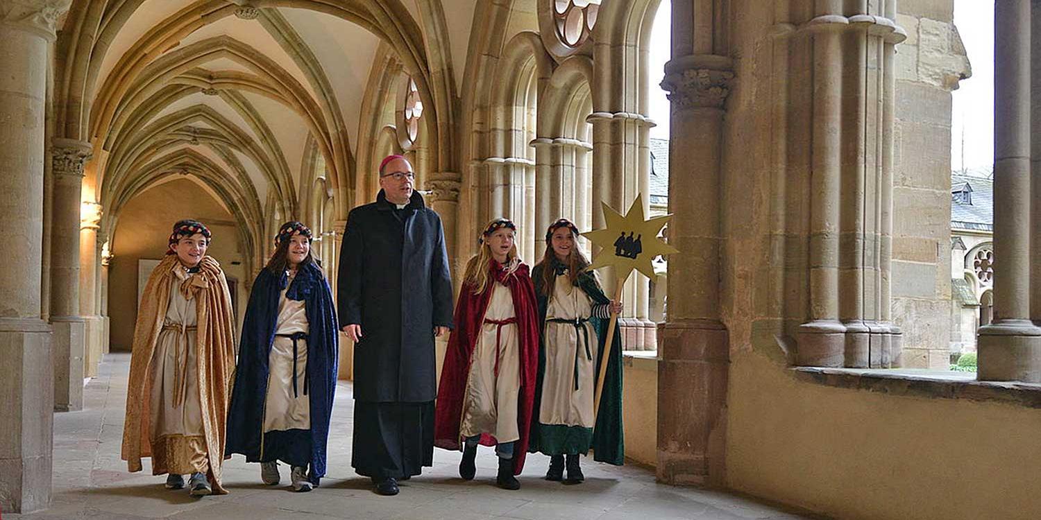 Sternsinger aus der Trierer Pfarrei St. Martin mit Bischof Stephan Ackermann im Domkreuzgang