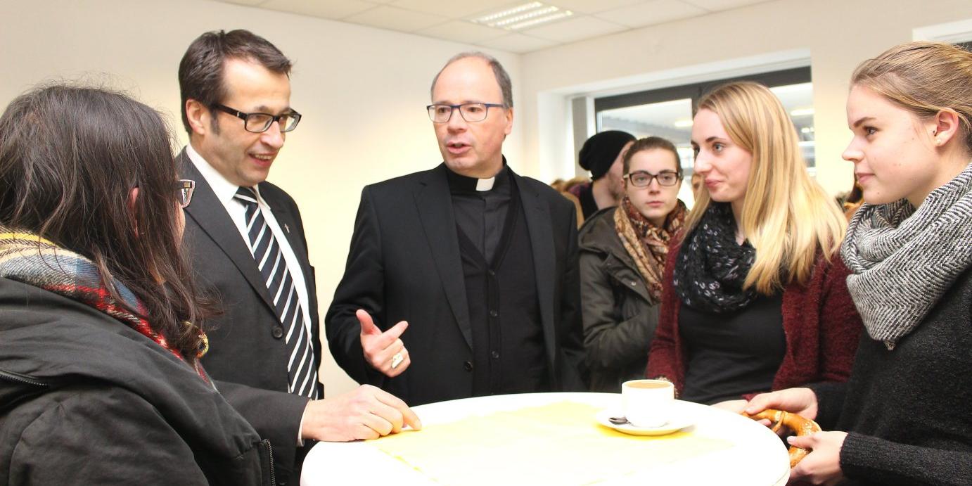 Bischof Stephan Ackermann (Mitte) und Rektor Martin Klose (zweiter von links) im Gespräch mit Studierenden der KH Mainz. Der Trierer Bischof weihte den zweiten Standort der Hochschule ein. © Bistum Mainz / Blum