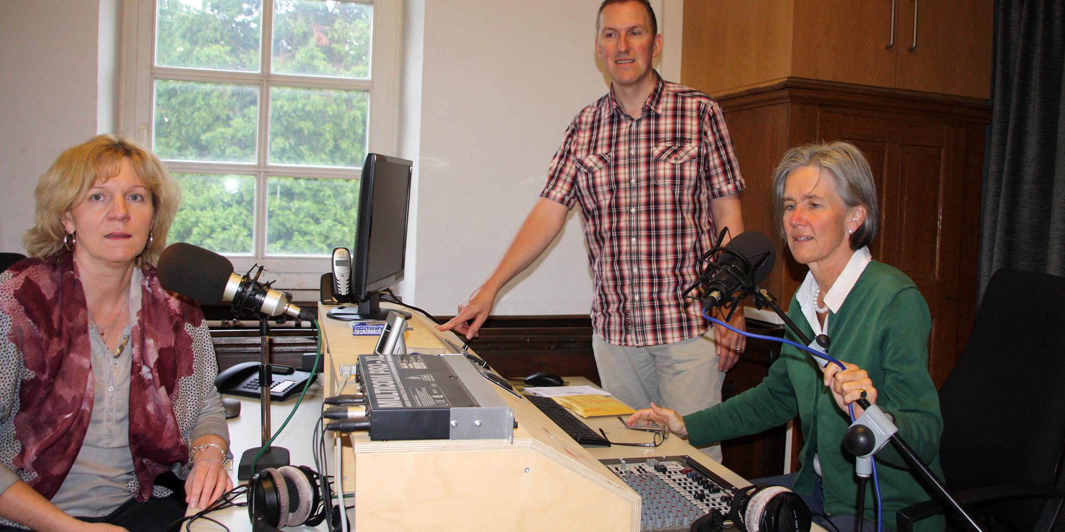Die Moderatorinnen Karin Berg und Donata Gräfin von Plettenberg (v.l.) und Techniker Olaf Budde sind alle Ehrenamtliche der ersten Stunde bei dem Privatsender domradio Studio-Nahe. Hier zu sehen im Studio im Kirchturm der Pfarrkirche Maria Geburt in Bretzenheim.