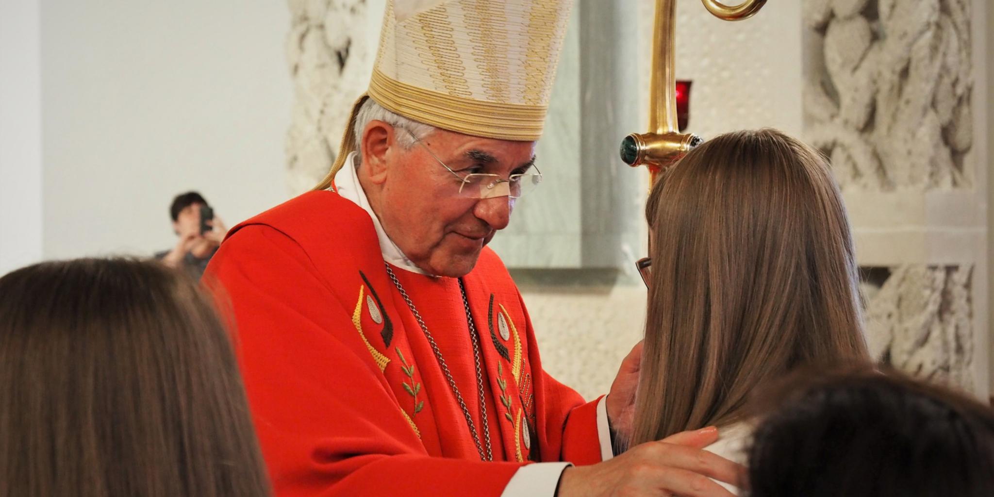 „Sei besiegelt durch die Gabe Gottes, den Heiligen Geist“: Weihbischof Gebert legt seine Hand auf Haupt und Schulter der Firmlinge.