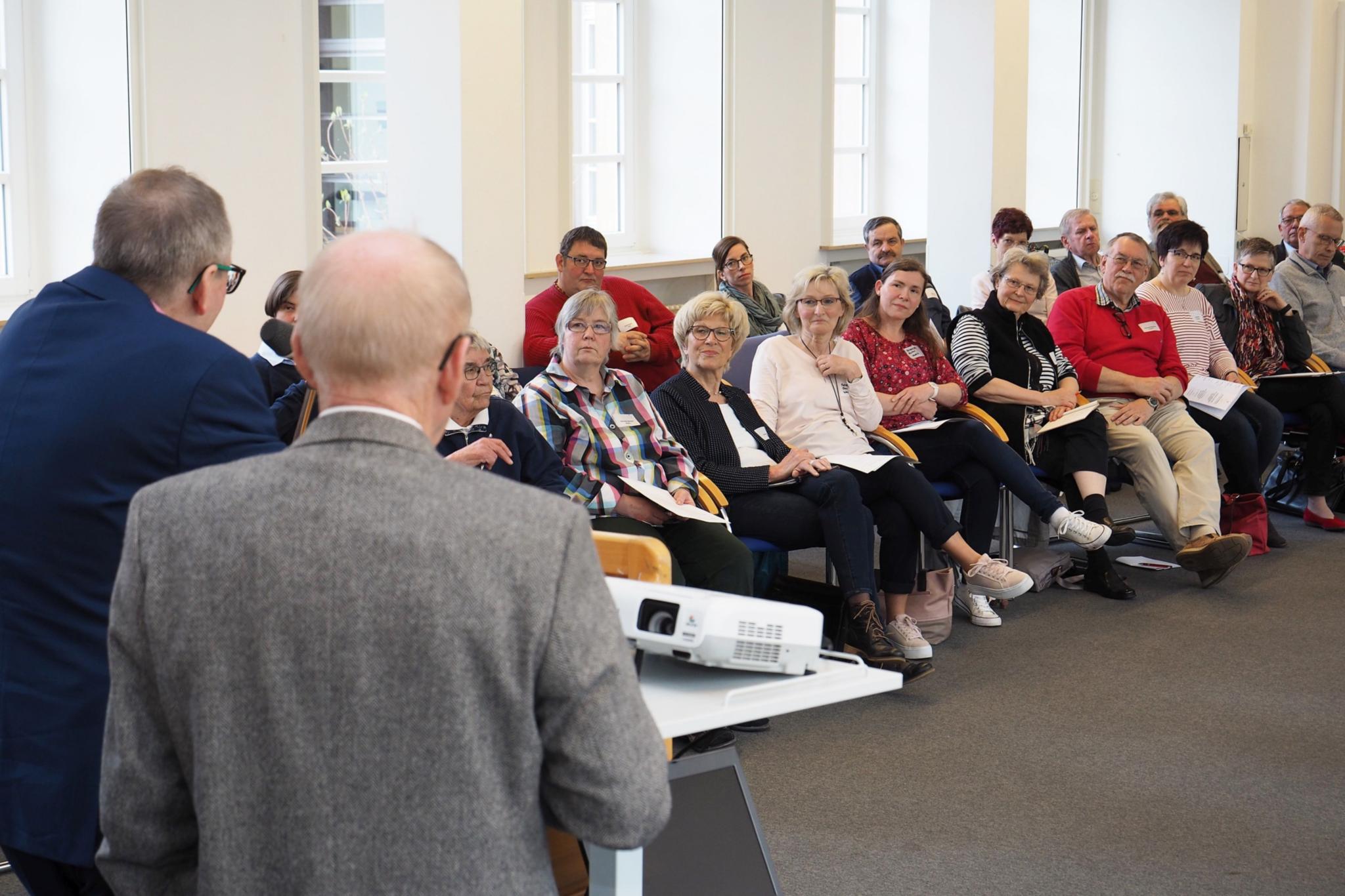 Viele ehrenamtlich Engagierte aus dem Bistum Trier folgen den Ausführungen von Dr. Hubertus Schönemann (vorne links), daneben Dr. Clemens Keller.