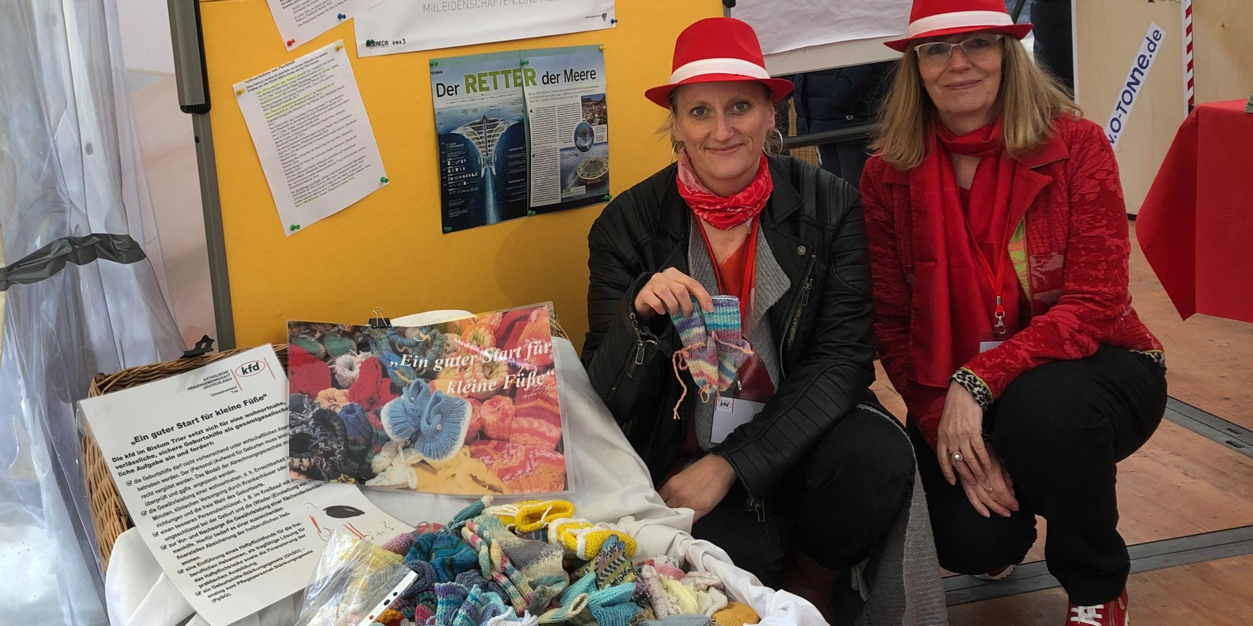 Anne Sturm und Monika Schuler (rechts) mit dem bis an den Rand gefüllten Korb voll gestrickter Babysöckchen der kfd-Frauen. gemeinsam mit Forderungen nach einer verbesserten Geburtshilfe werden diese symbolisch an die Gesundheitsministerinnen von RLP und Saarland überreicht