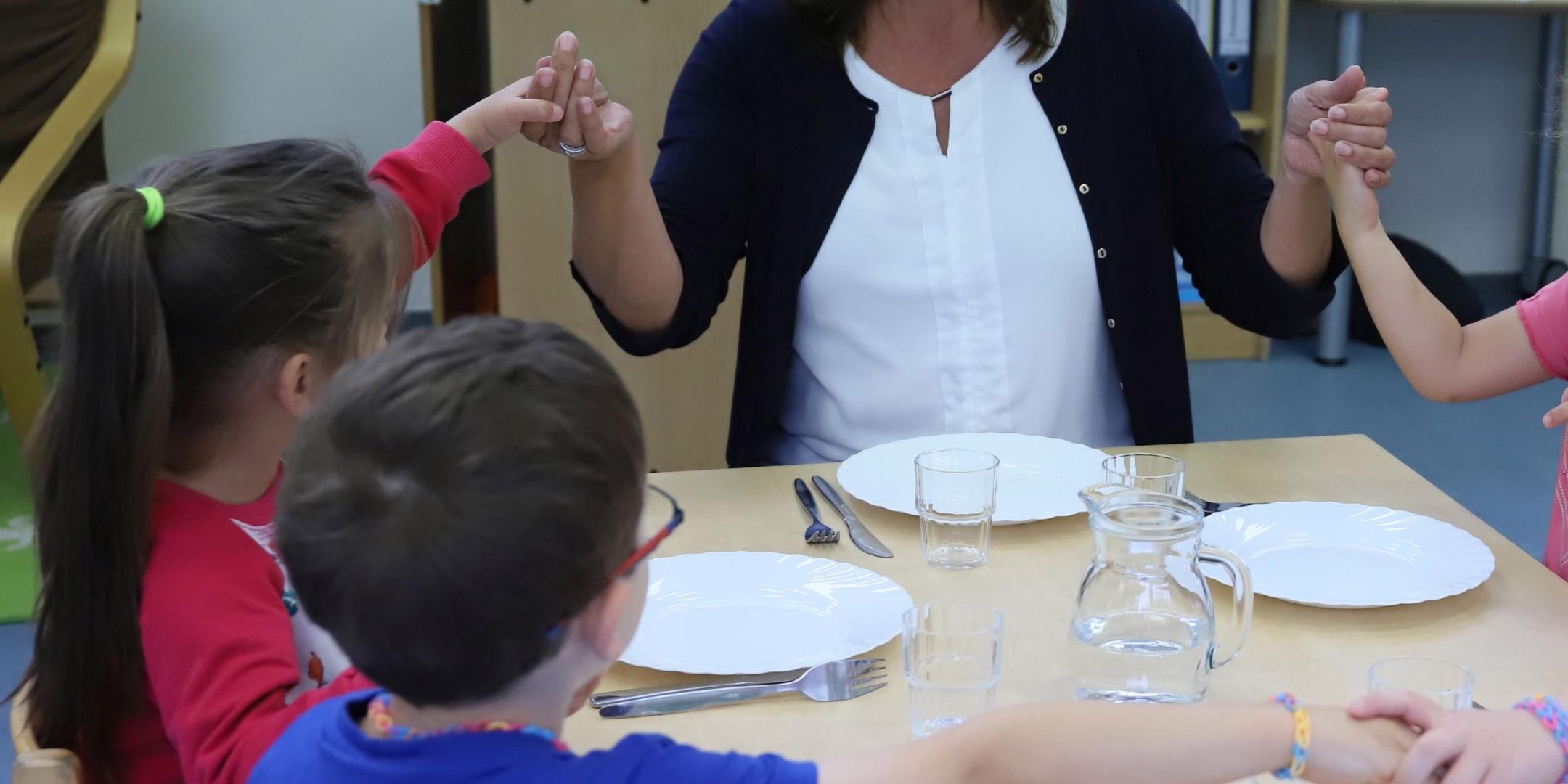 Birgit Simon von der Kita Christi Himmelfahrt in Trier-Ehrang mit den Kindern zusammen beim Mittagstisch.