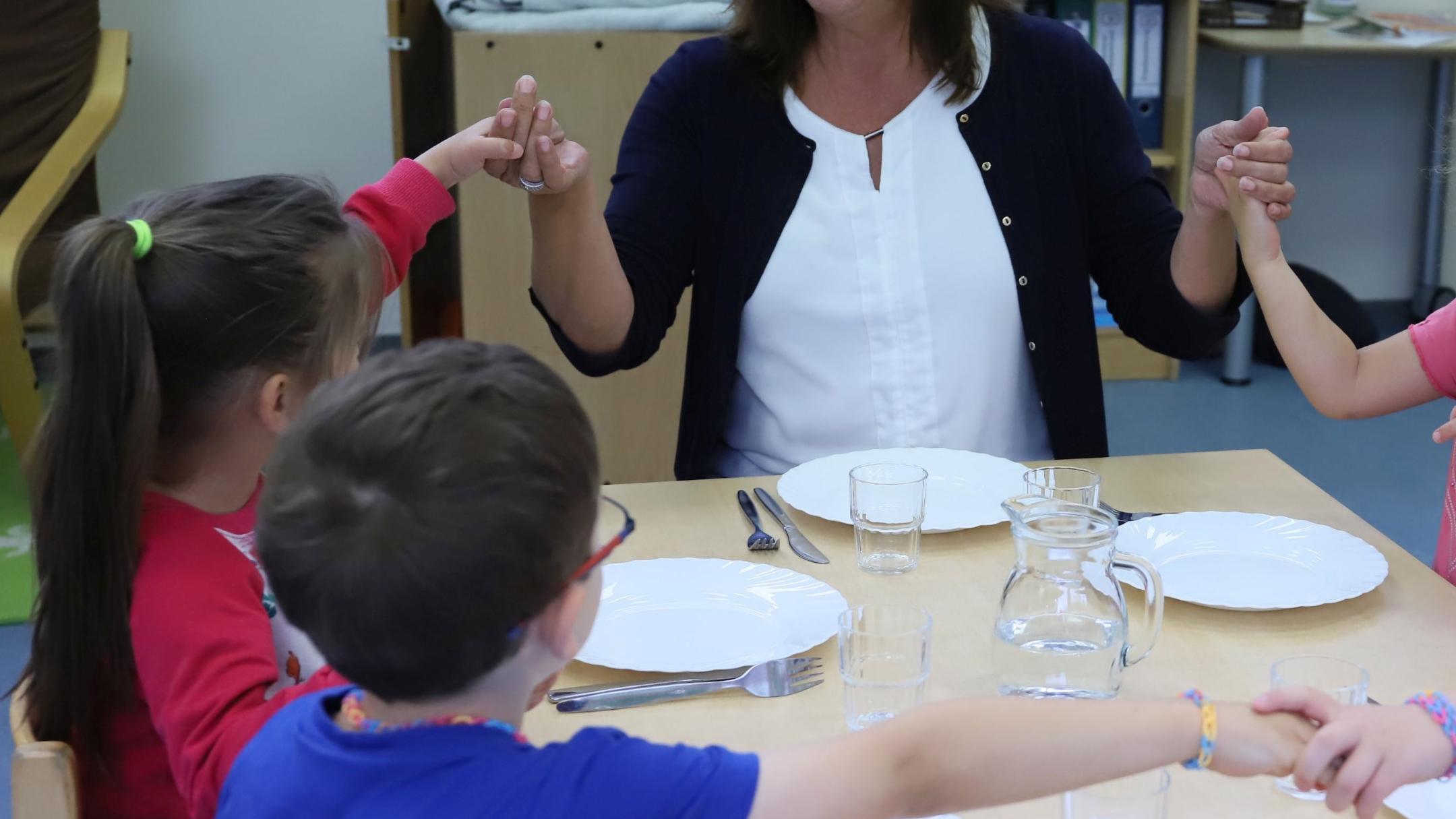 Birgit Simon von der Kita Christi Himmelfahrt in Trier-Ehrang mit den Kindern zusammen beim Mittagstisch.