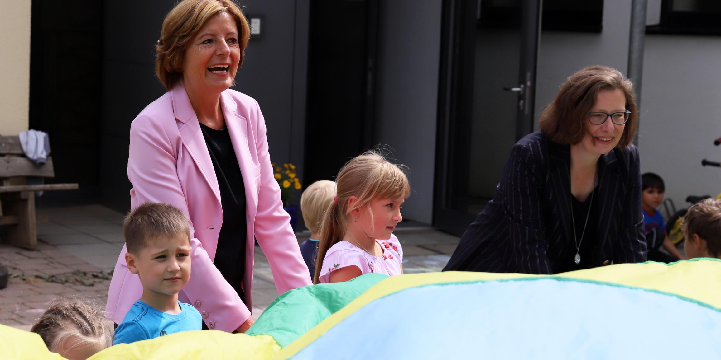 Malu Dreyer (links) und Geschäftsführerin der Kita gGmbH Trier, Cordula Scheich, beim Spiel mit den Kindern in der Dauner Kita Thomas Morus.