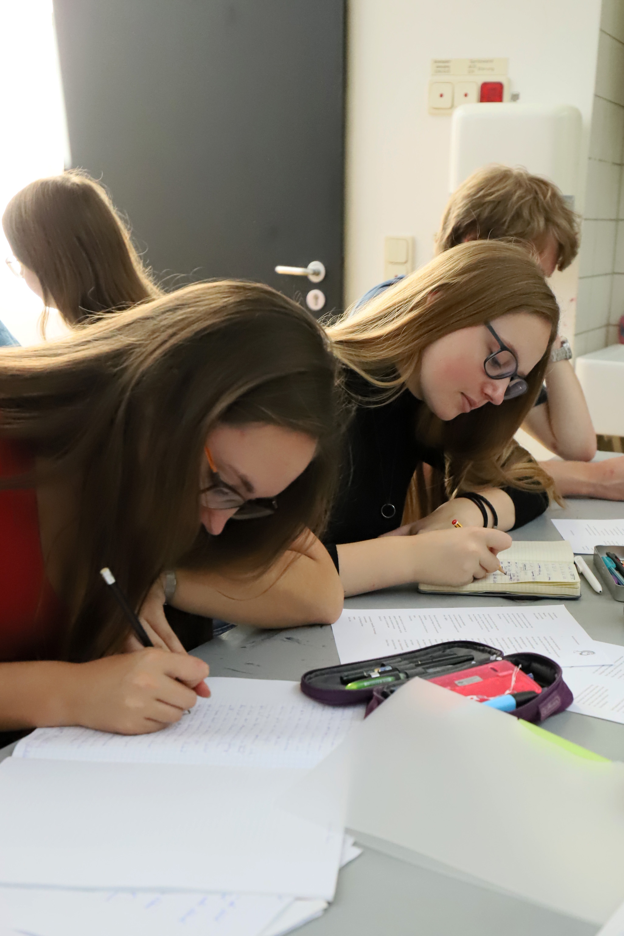 Die Schülerinnen schreiben ihre Texte nieder.