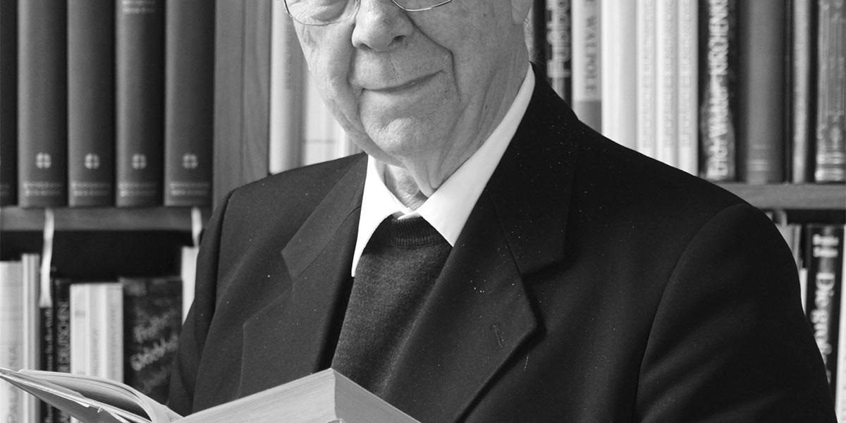 Prälat Professor Dr. Dr. Franz Ronig vor einem Bücherregal