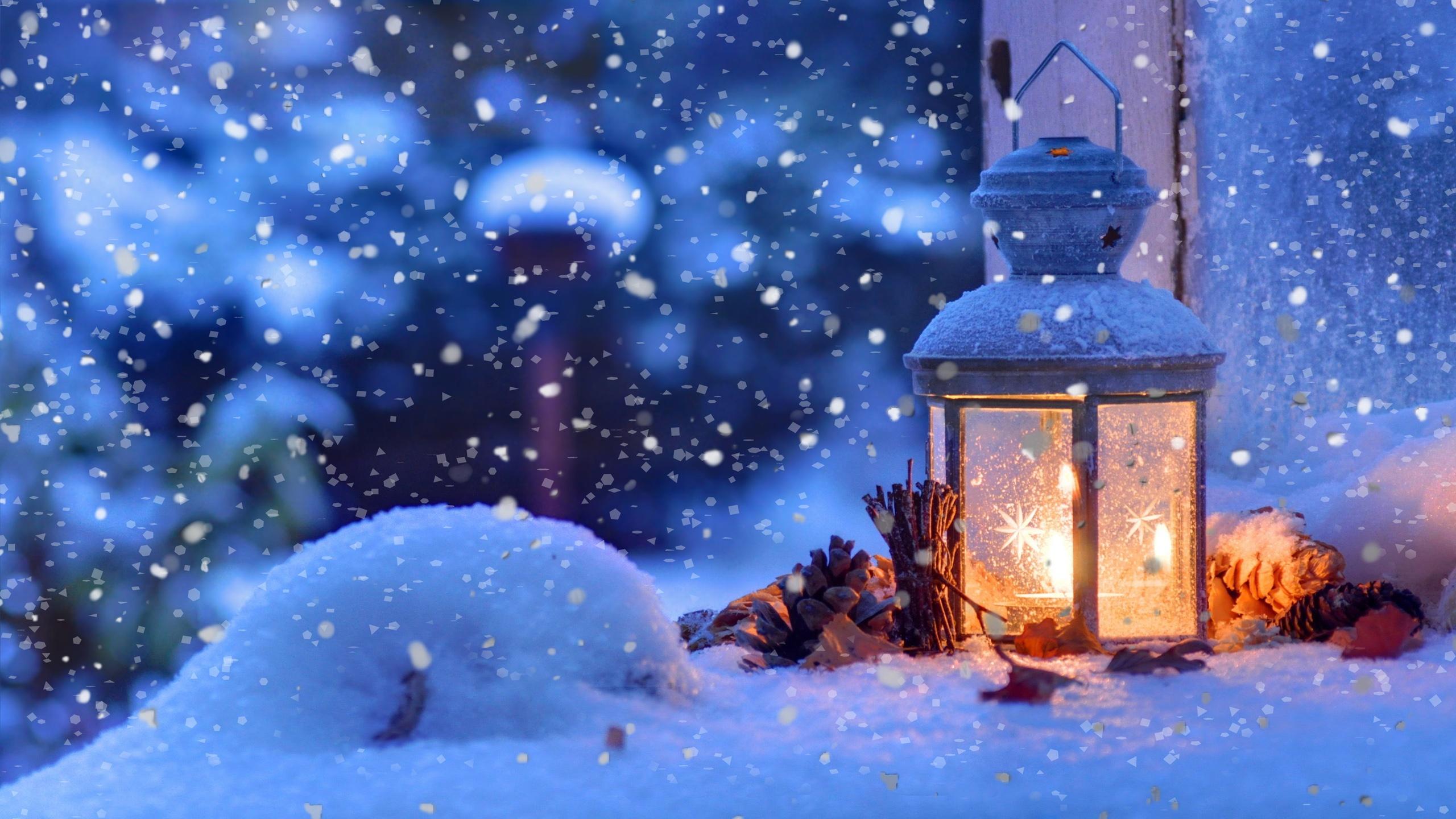 Auf dem Titelbild des diesjährigen Adventskalenders ist eine verschneite Laterne, vor einem Fenster in weihnachtlicher Abendstimmung zu sehen.