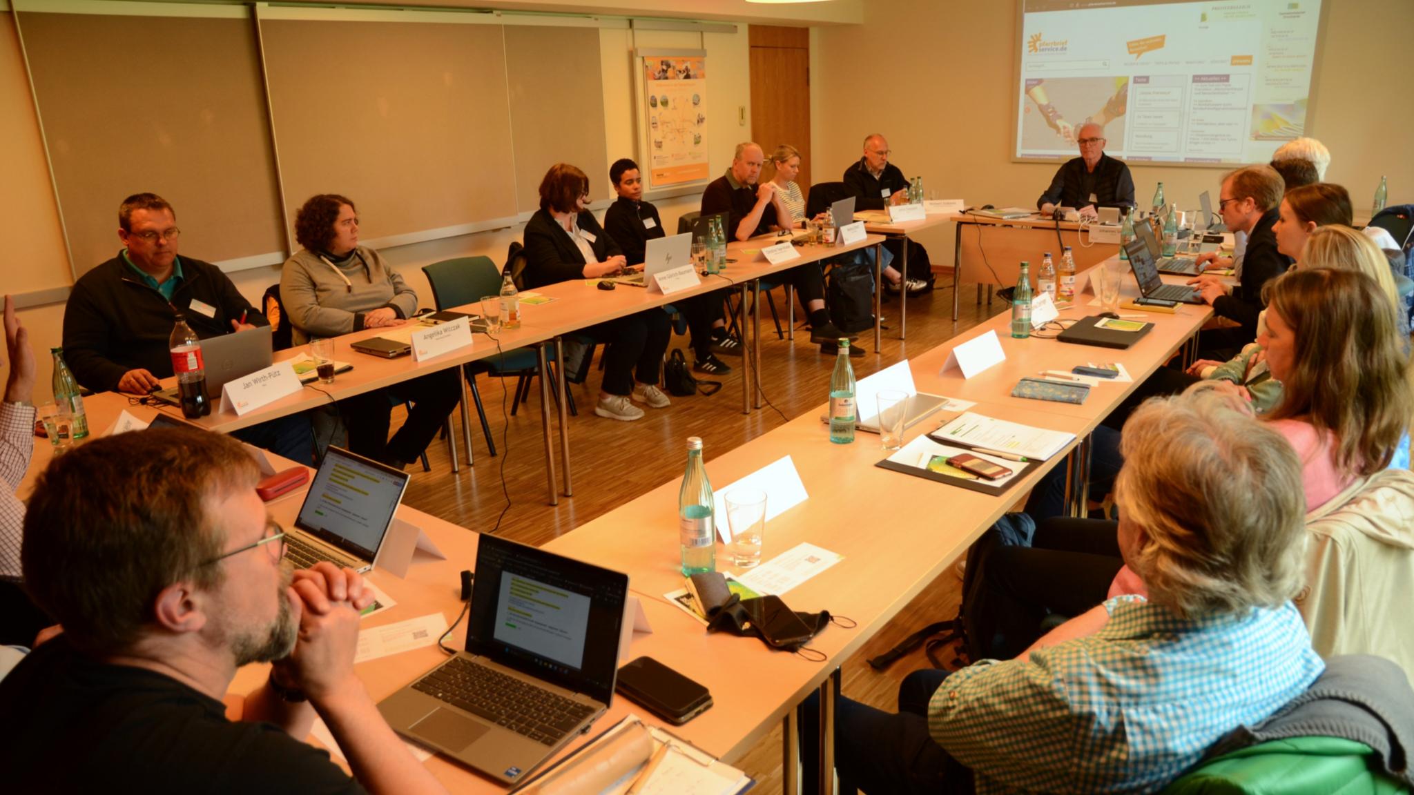 Zum letzten Mal in diesem Setting: Johannes Simon (vor der Leinwand) moderierte die Bundeskonferenz 2025 von Pfarrbriefservice.de. Er wird im Oktober 2025 in den Ruhestand gehen.