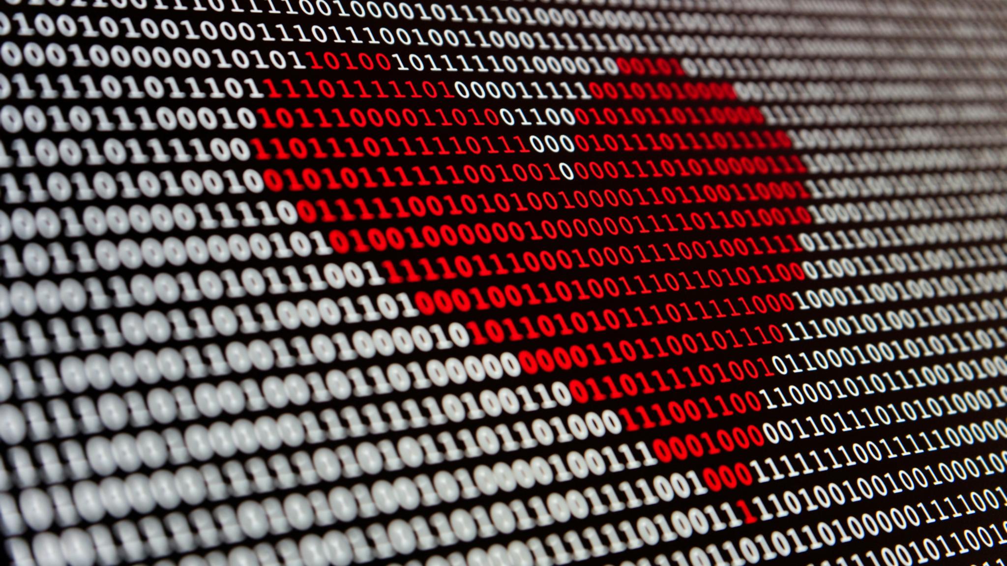 Reihen mit weißen Nullen und Einsen vor schwarzem Hintergrund; in der Mitte ist ein rotes Herz markiert