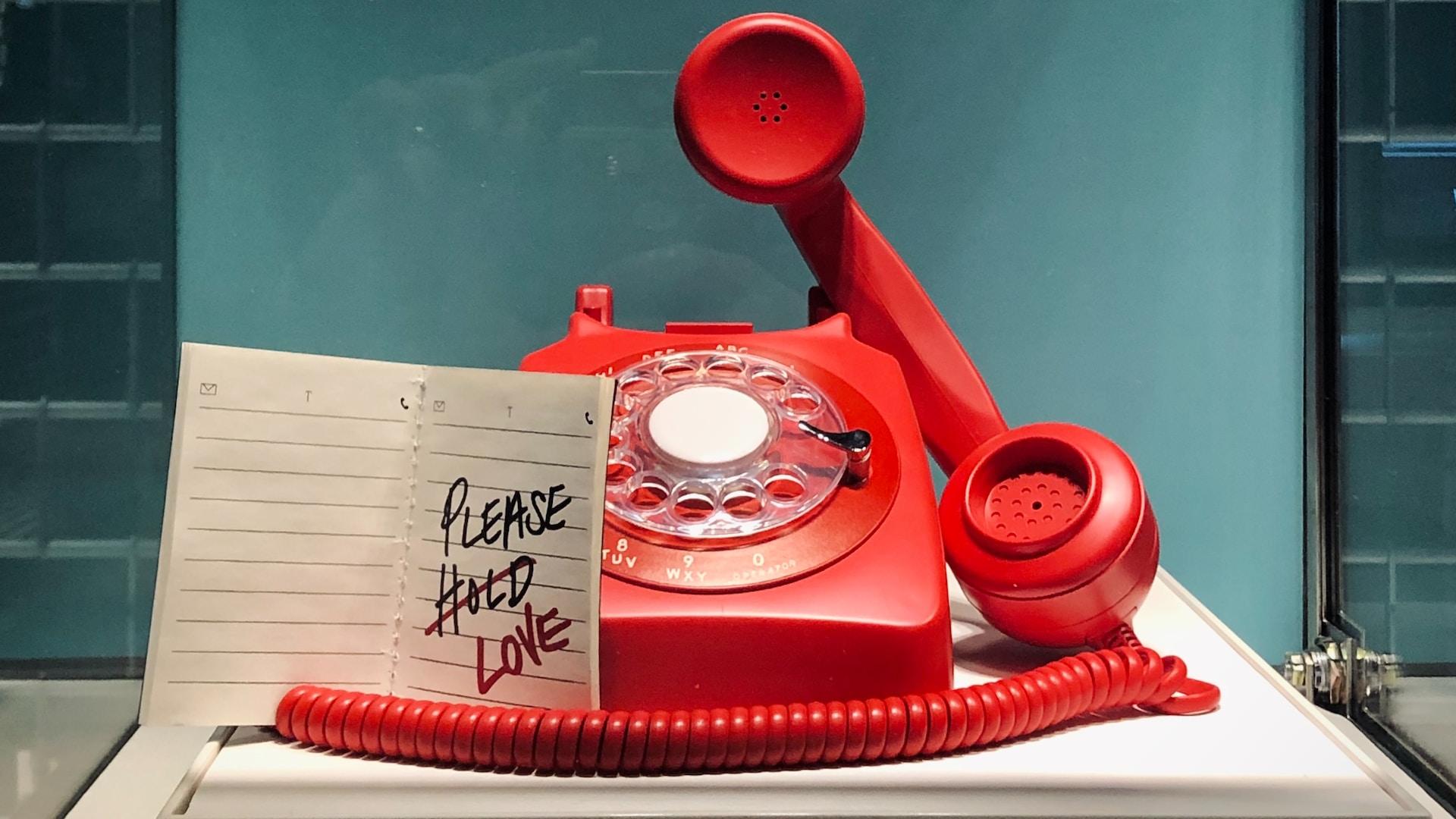 altmodisches rotes Telefon mit offenem Hörer