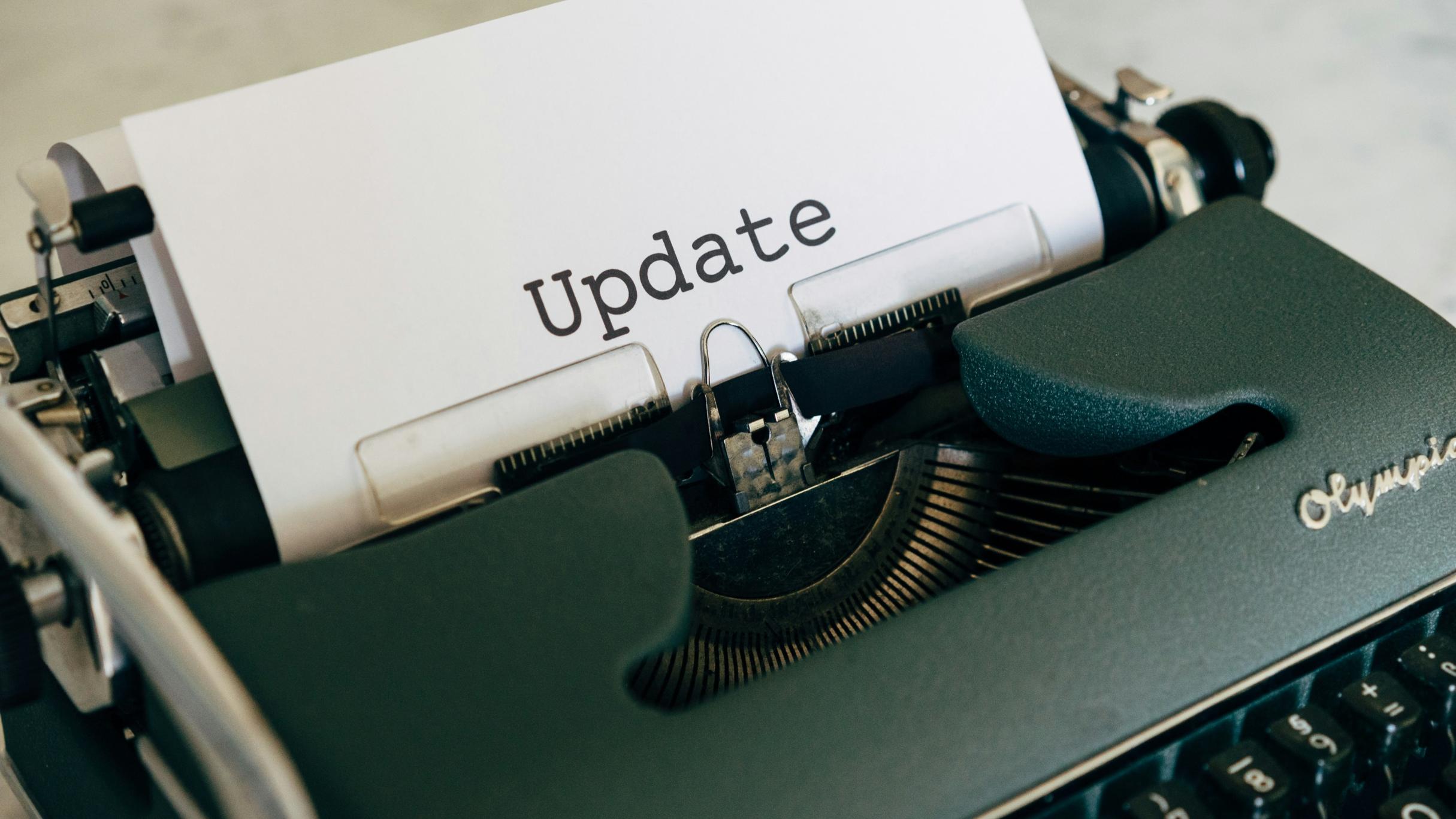 In einer Schreibmaschine steckt ein Zettel, auf dem 'Update' steht