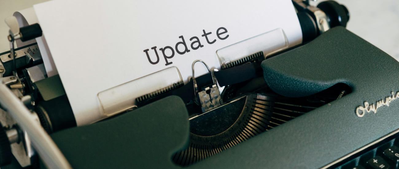 In einer Schreibmaschine steckt ein Zettel, auf dem 'Update' steht